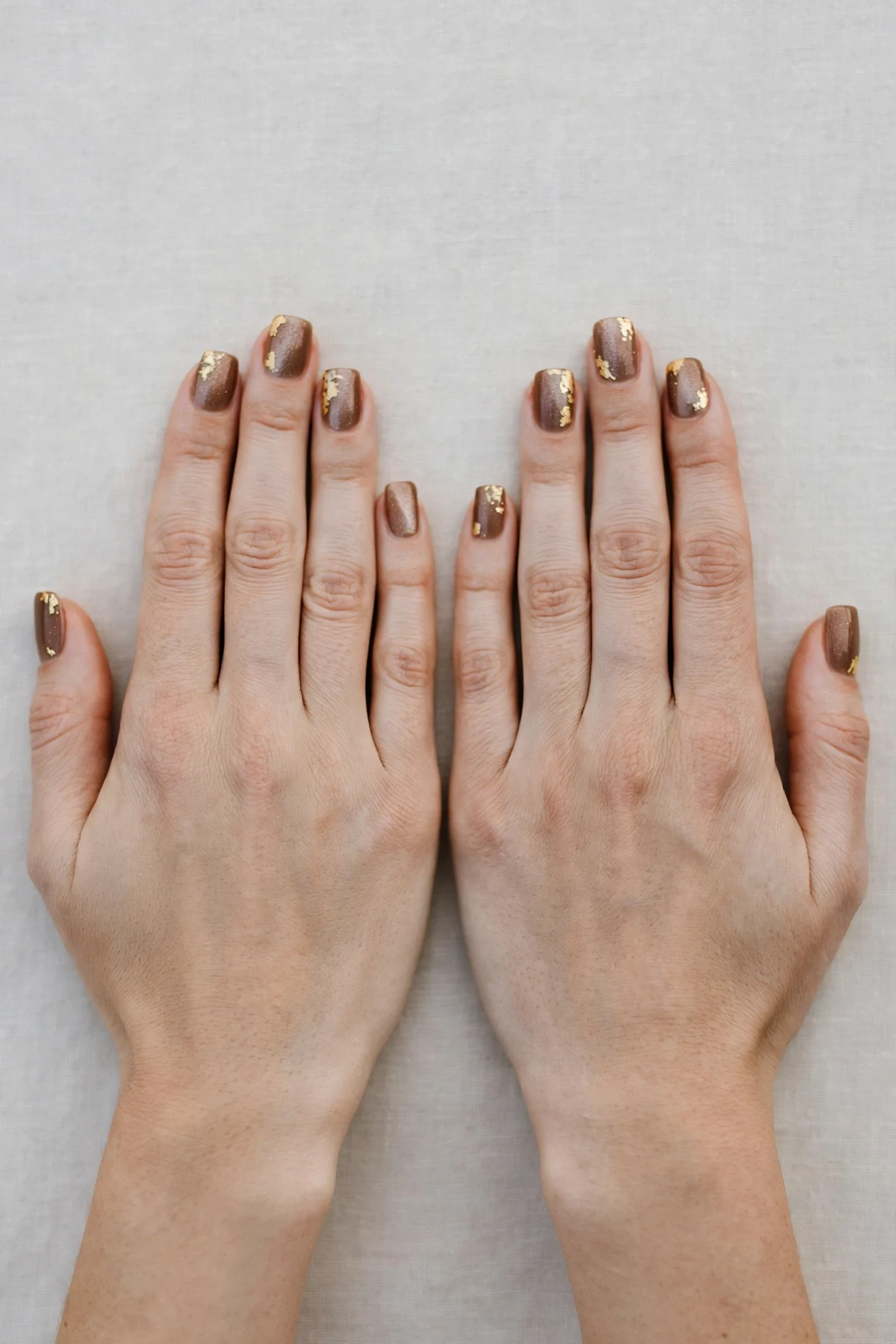 30 Brown Neutral Christmas Nails For Women In Their 20S With Short Square Nails That Are Chic, Warm and Elegant 7 Brown Neutral Christmas Nails with a frosted shimmer finish and gold foil accents