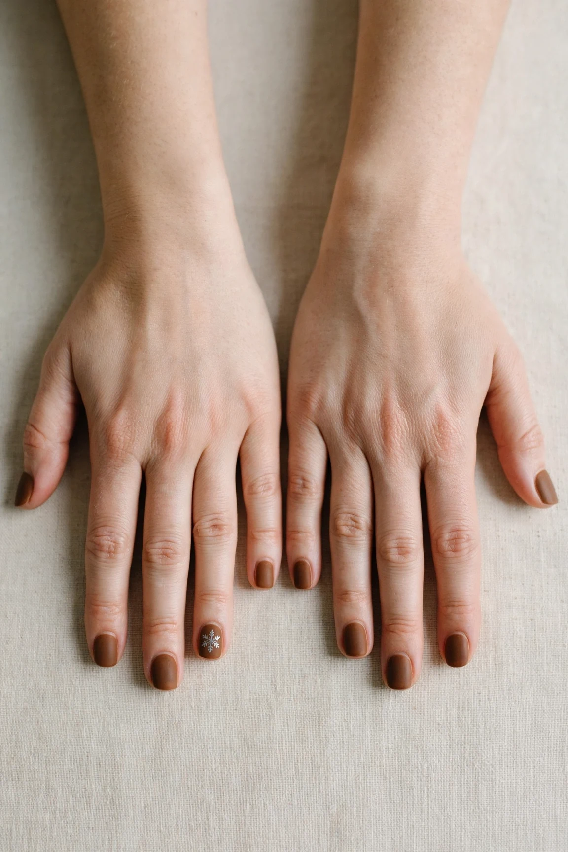 30 Brown Neutral Christmas Nails For Women In Their 20S With Short Square Nails That Are Chic, Warm and Elegant 28 Brown Neutral Christmas Nails with a velvet matte finish and a delicate snowflake on the ring finger