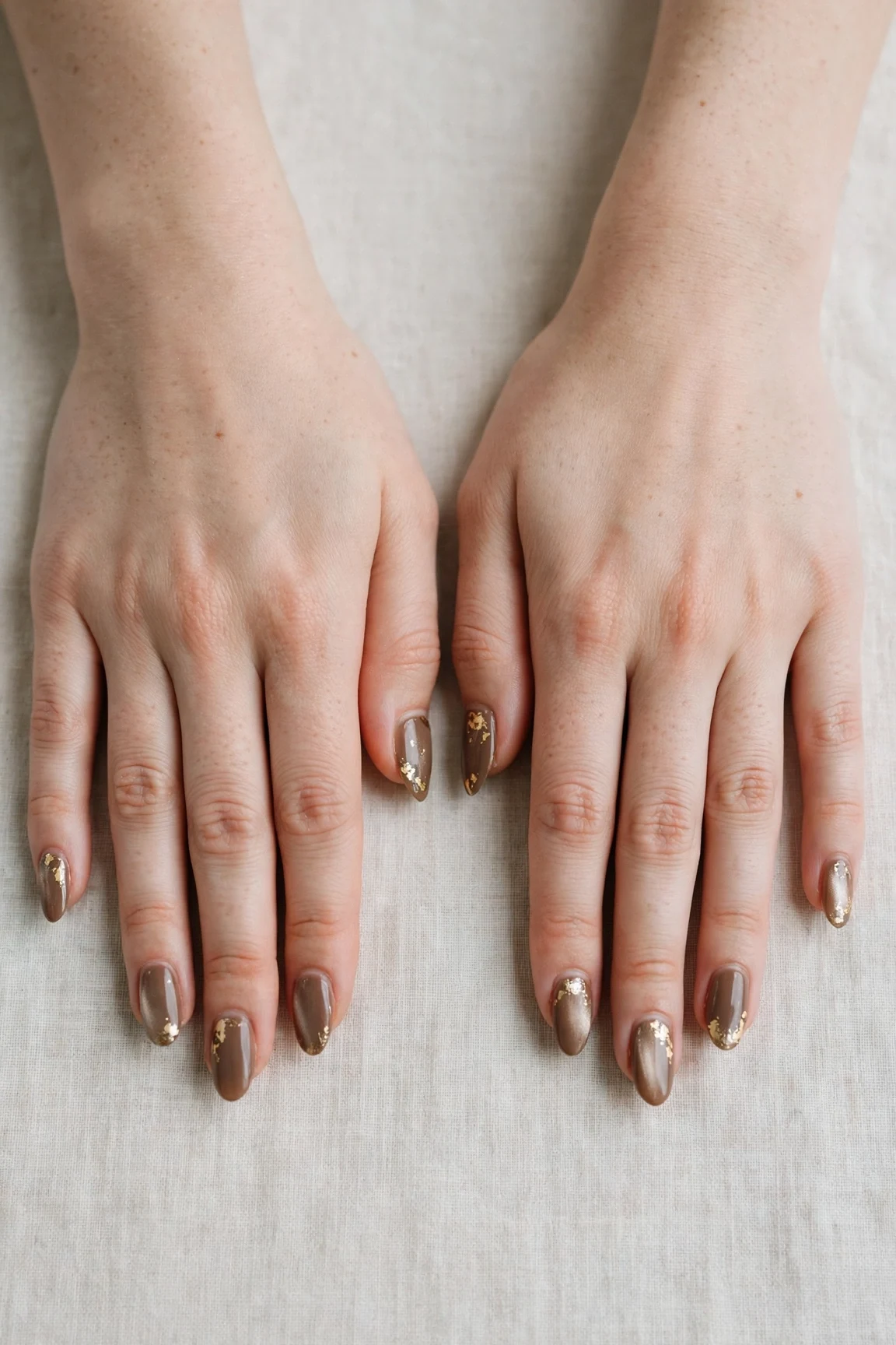 Almond Brown Neutral Matte Christmas Nails with a pearl shimmer finish and gold foil accents