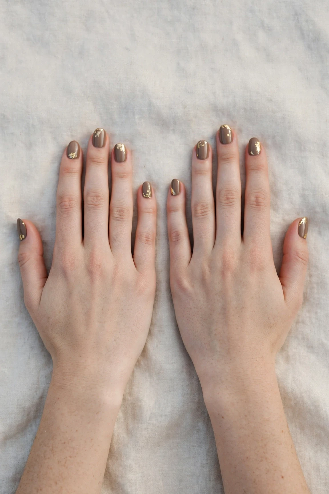 Oval Brown Neutral Matte Christmas Nails with a satin finish and gold foil accents