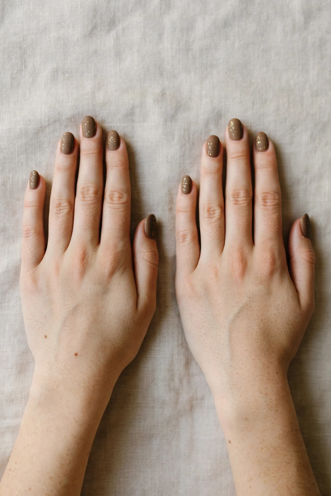 Oval Brown Neutral Matte Christmas Nails with a velvet matte finish and tiny gold dots