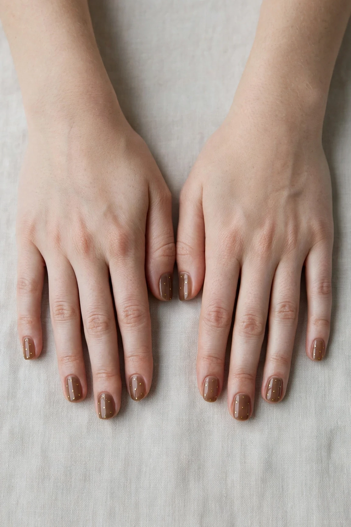 Squoval Brown Neutral Matte Christmas Nails with a sheer jelly finish and tiny gold dots