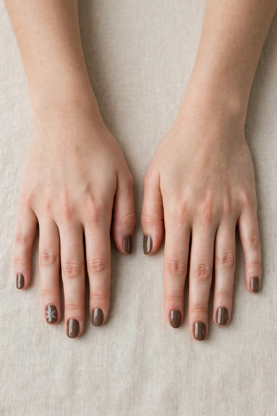 Short Oval Brown Neutral Matte Christmas Nails with a high-gloss finish and a delicate snowflake on the ring finger