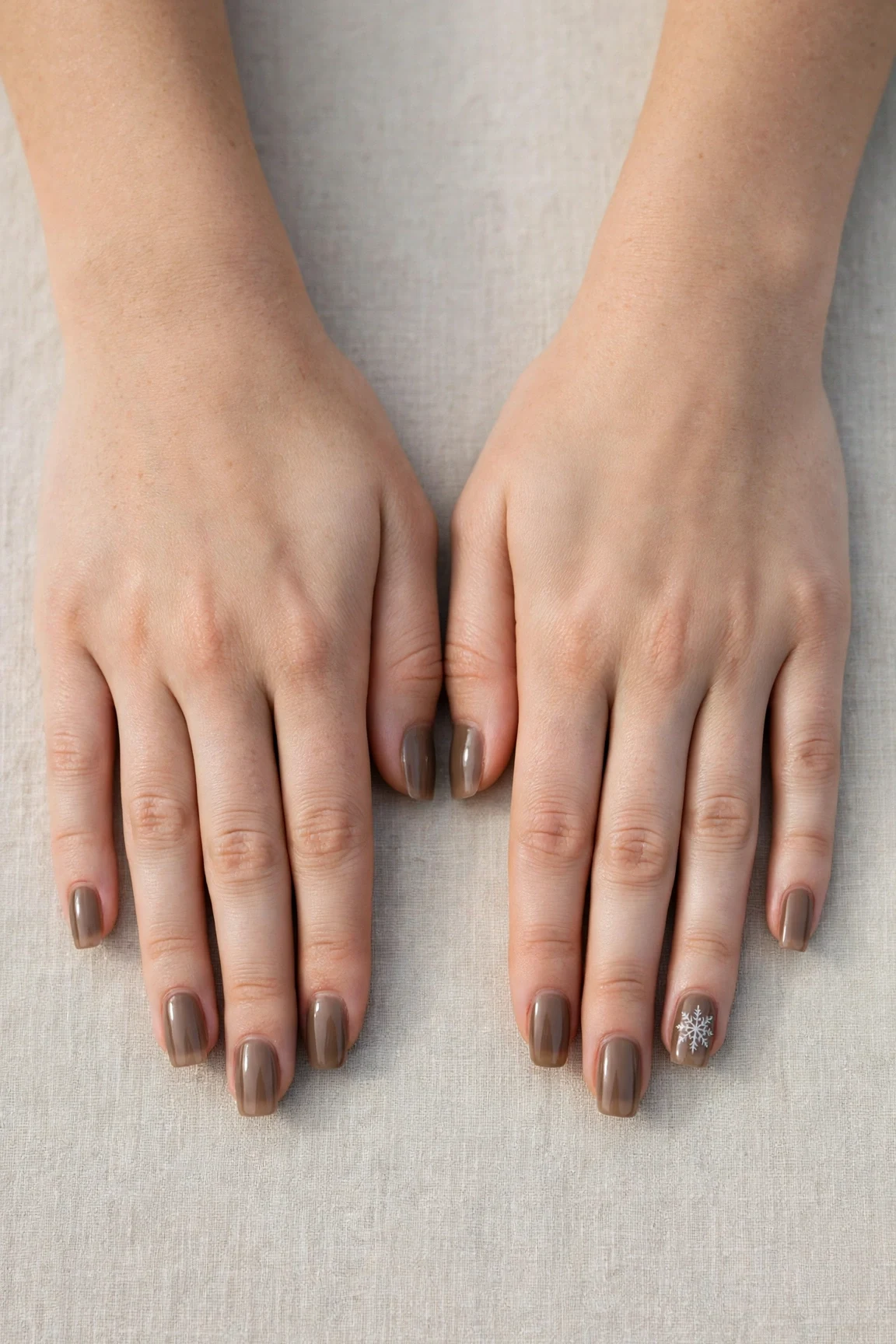 Squoval Brown Neutral Matte Christmas Nails with a sheer jelly finish and a delicate snowflake on the ring finger