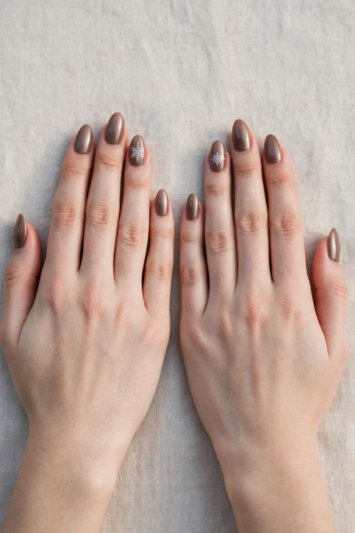 Almond Brown Neutral Matte Christmas Nails with a pearl shimmer finish and a delicate snowflake on the ring finger
