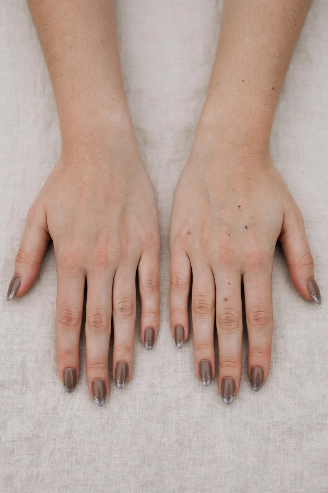 Almond Brown Neutral Matte Christmas Nails with a soft matte finish and silver shimmer tips