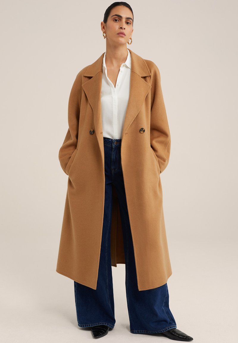 Camel Wool Coat With Dark Jeans and a White Blouse