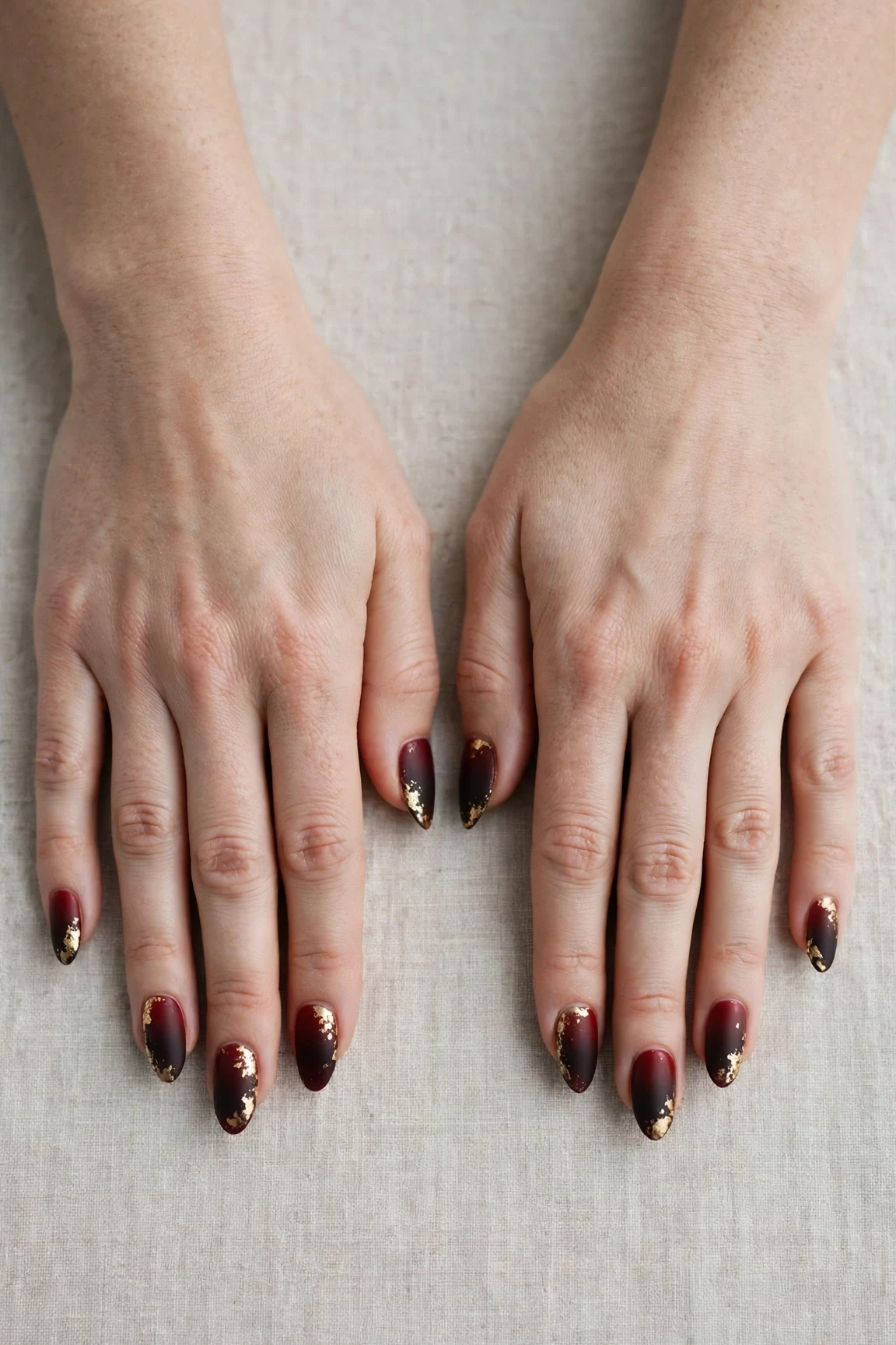 Almond Cherry Cola Ombre Nails with a soft matte finish and gold foil accents