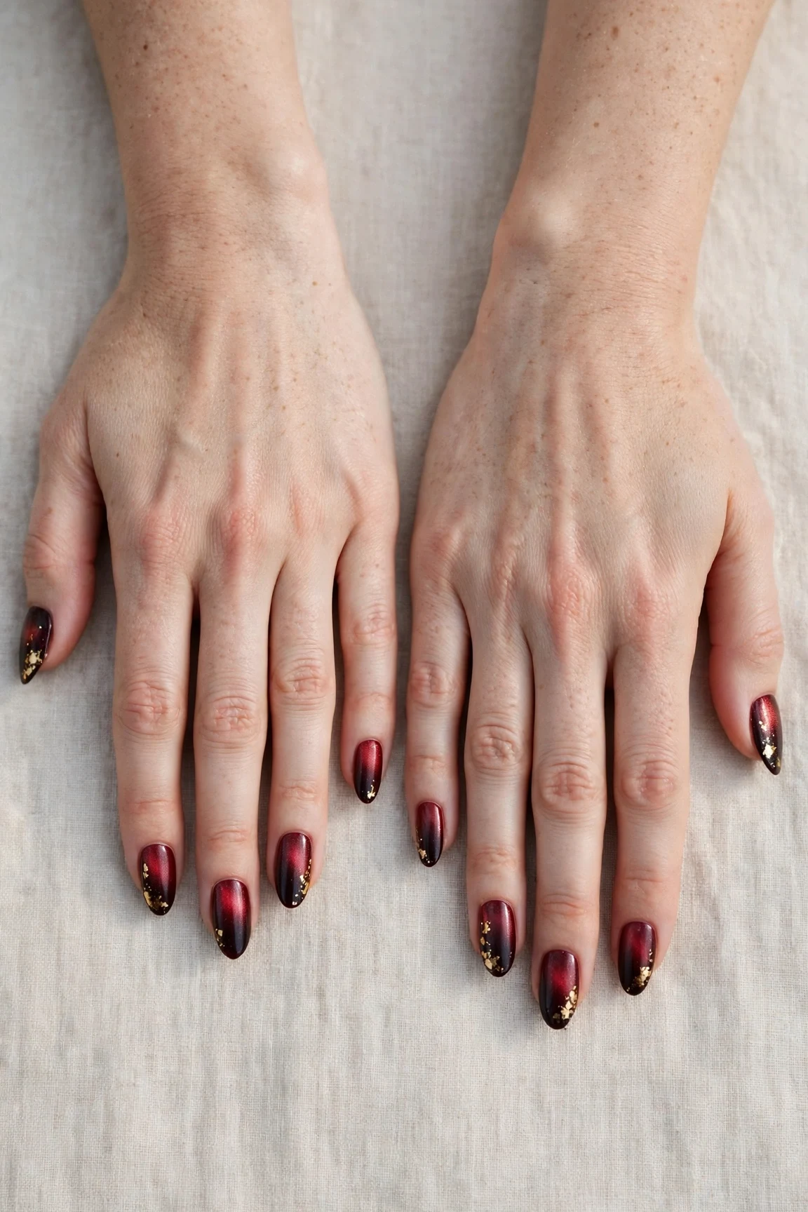 Almond Cherry Cola Ombre Nails with a pearl shimmer finish and gold foil accents