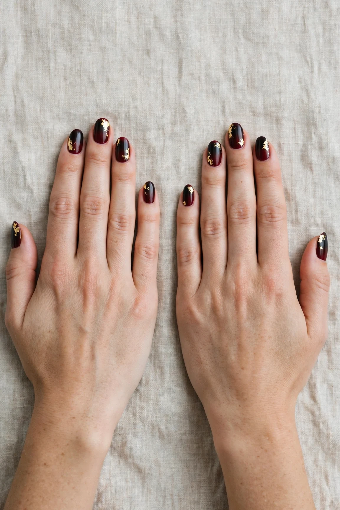 Oval Cherry Cola Ombre Nails with a satin finish and gold foil accents