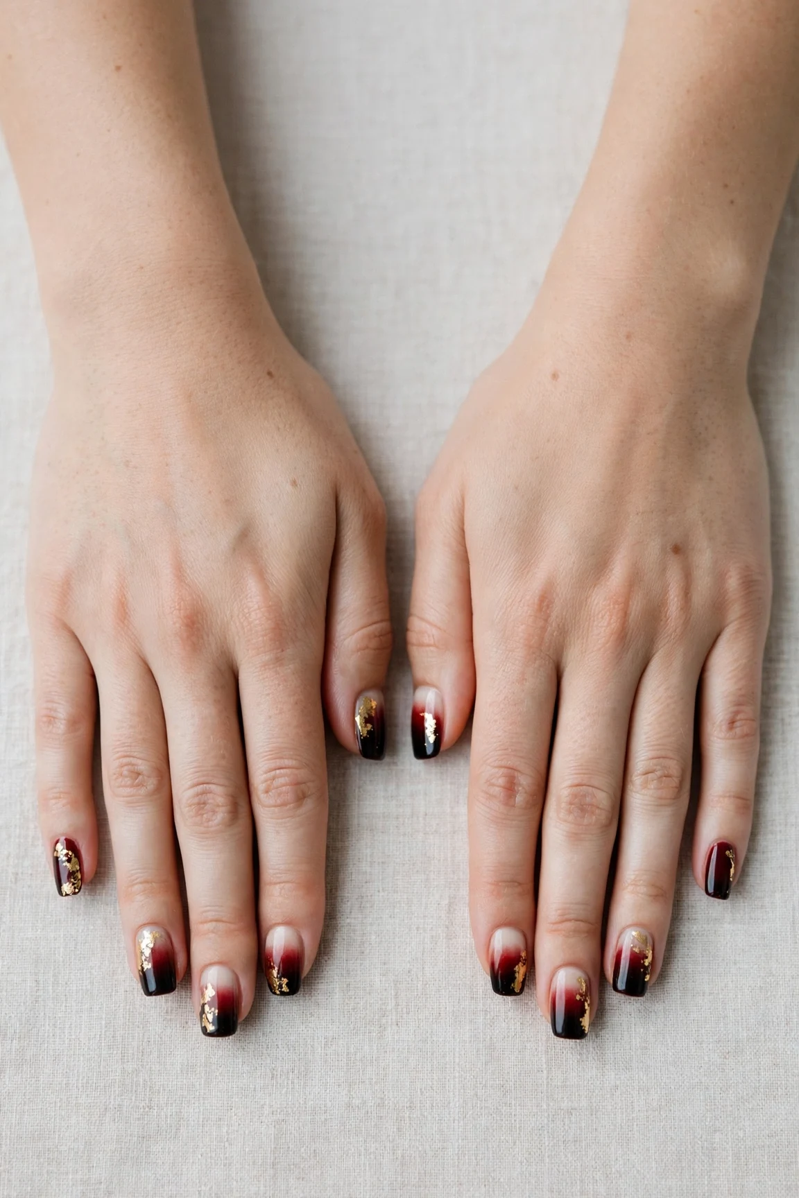 Squoval Cherry Cola Ombre Nails with a creamy opaque finish and gold foil accents