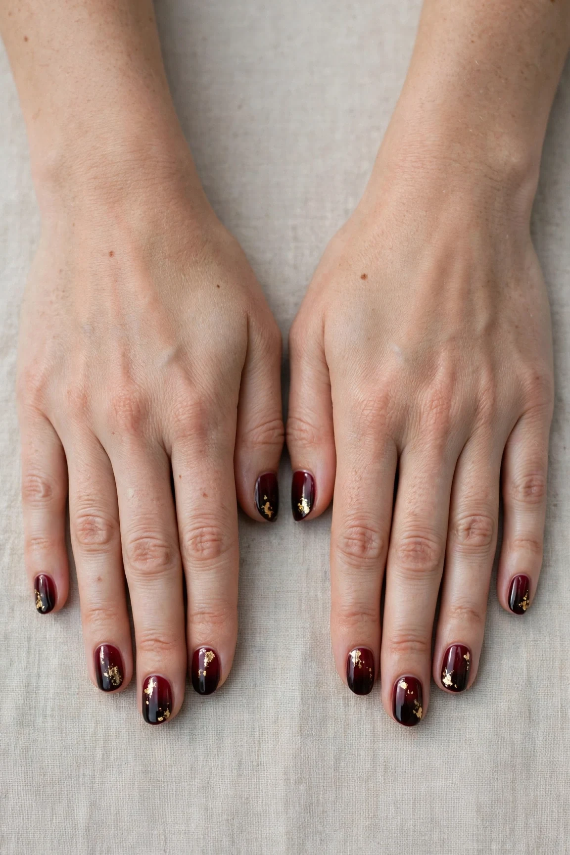 Short Round Cherry Cola Ombre Nails with a deep glossy shine and gold foil accents