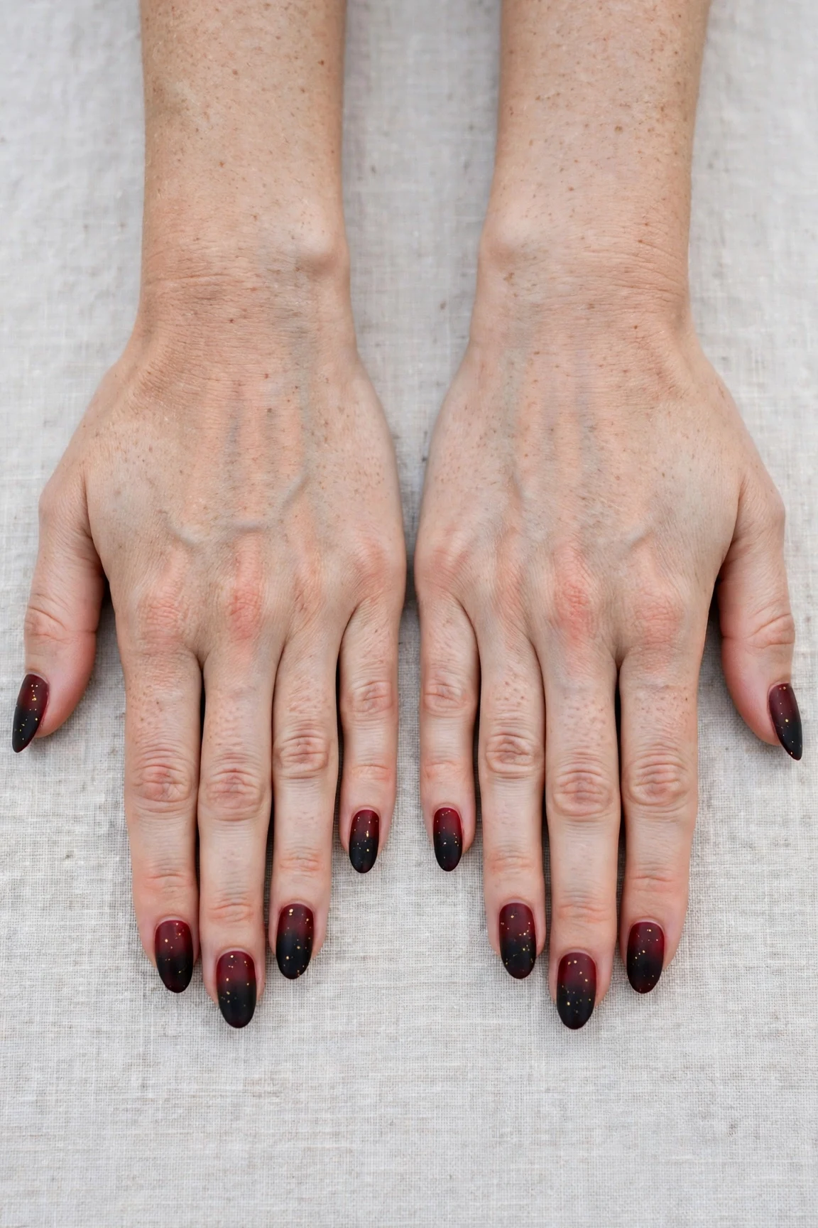 Almond Cherry Cola Ombre Nails with a soft matte finish and tiny gold dots