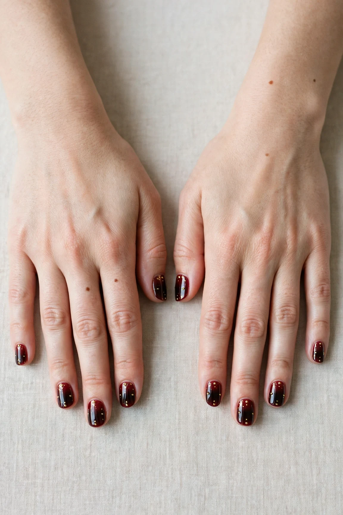 Short Square Cherry Cola Ombre Nails with a chrome shine and tiny gold dots