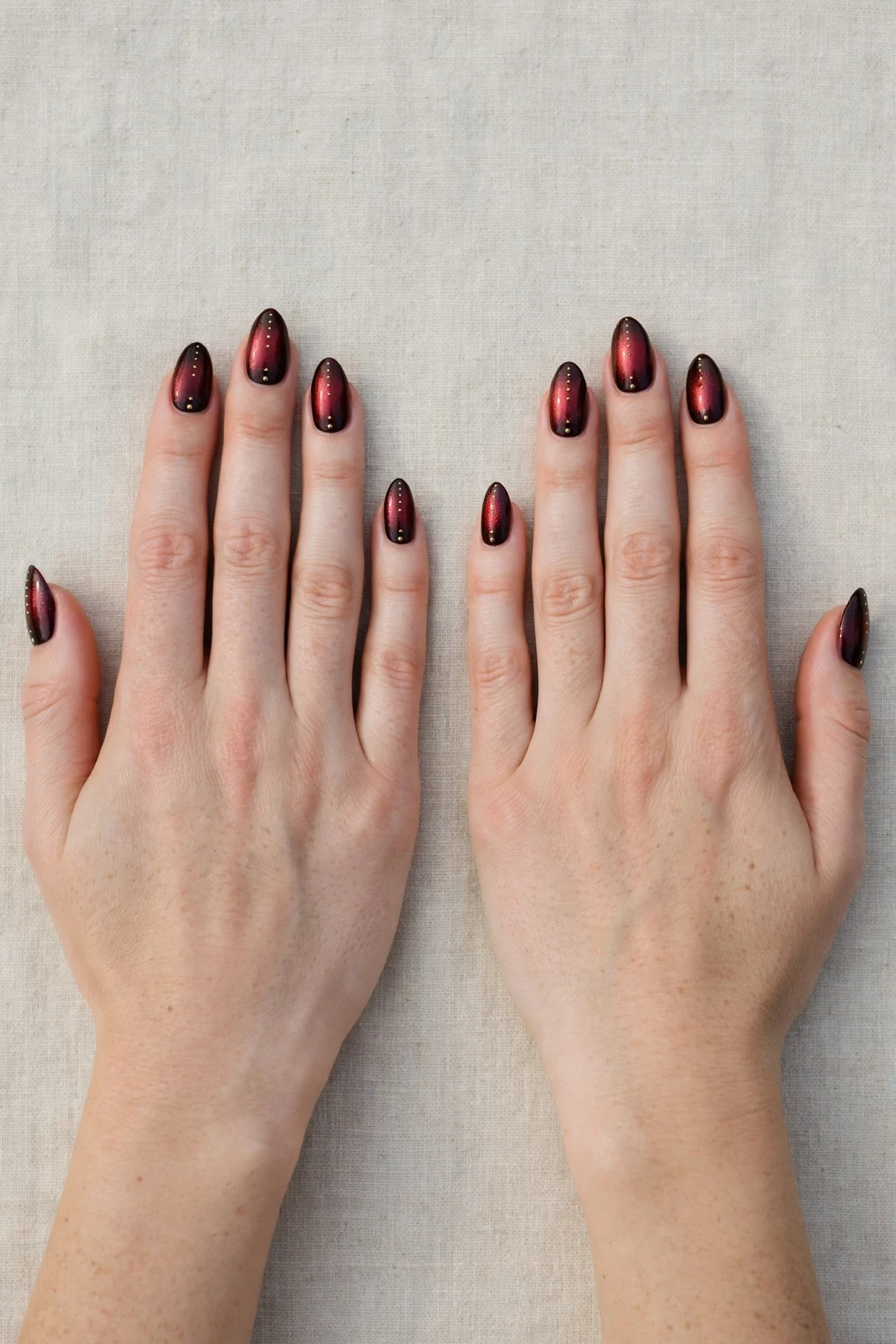 Almond Cherry Cola Ombre Nails with a pearl shimmer finish and tiny gold dots