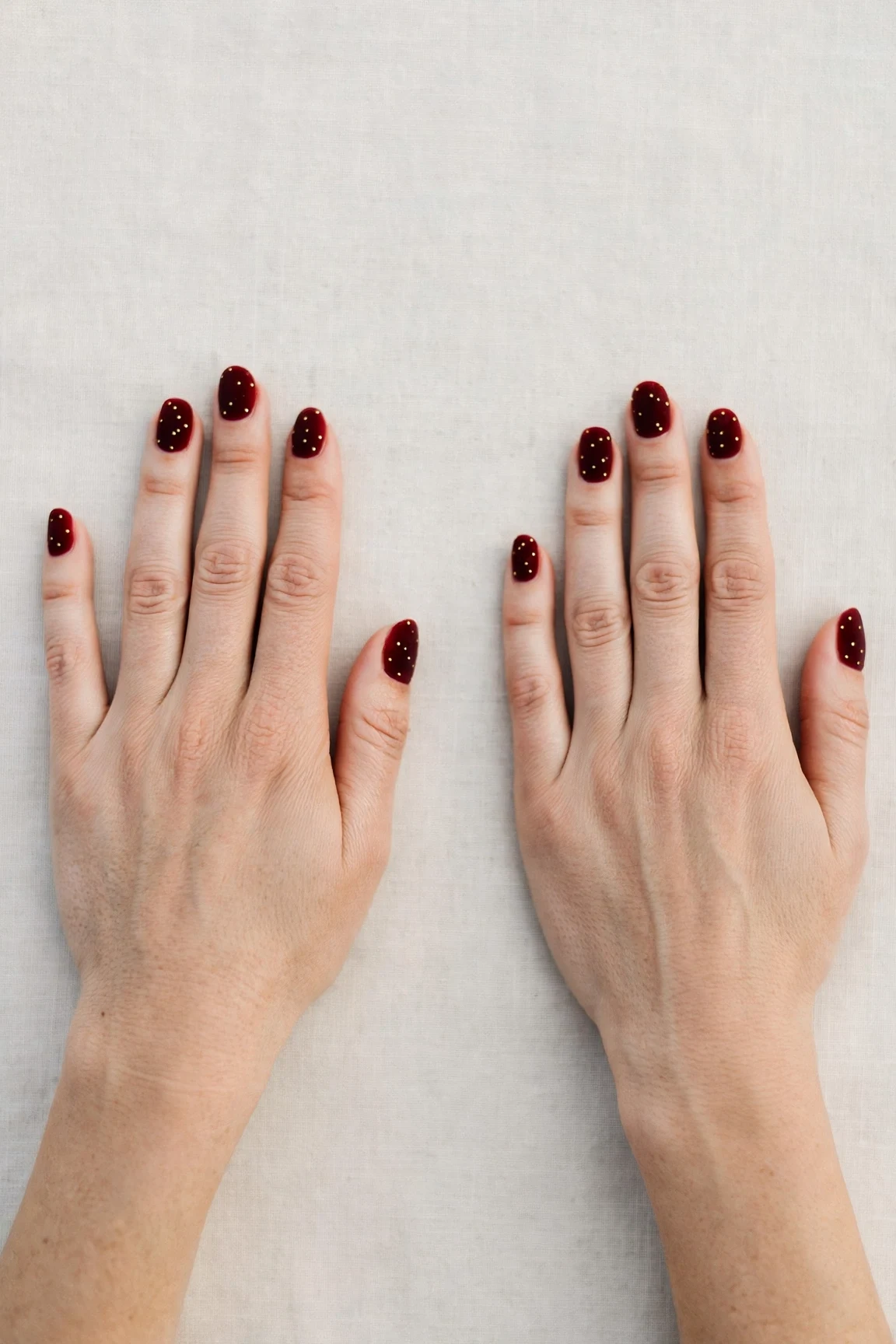 Oval Cherry Cola Velvet Finish Nails with a velvet matte finish and tiny gold dots