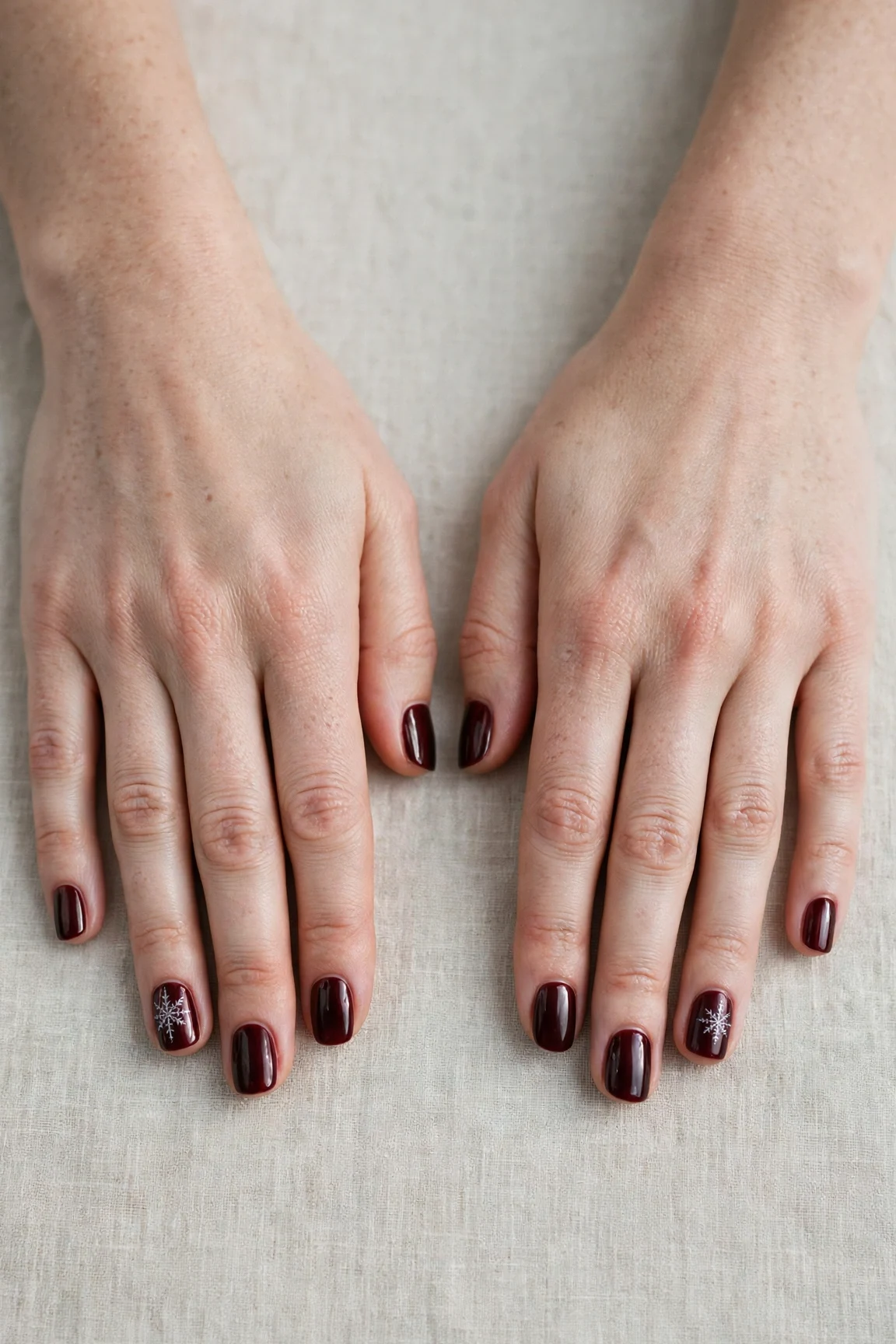 Short Square Cherry Cola Velvet Finish Nails with a chrome shine and a delicate snowflake on the ring finger