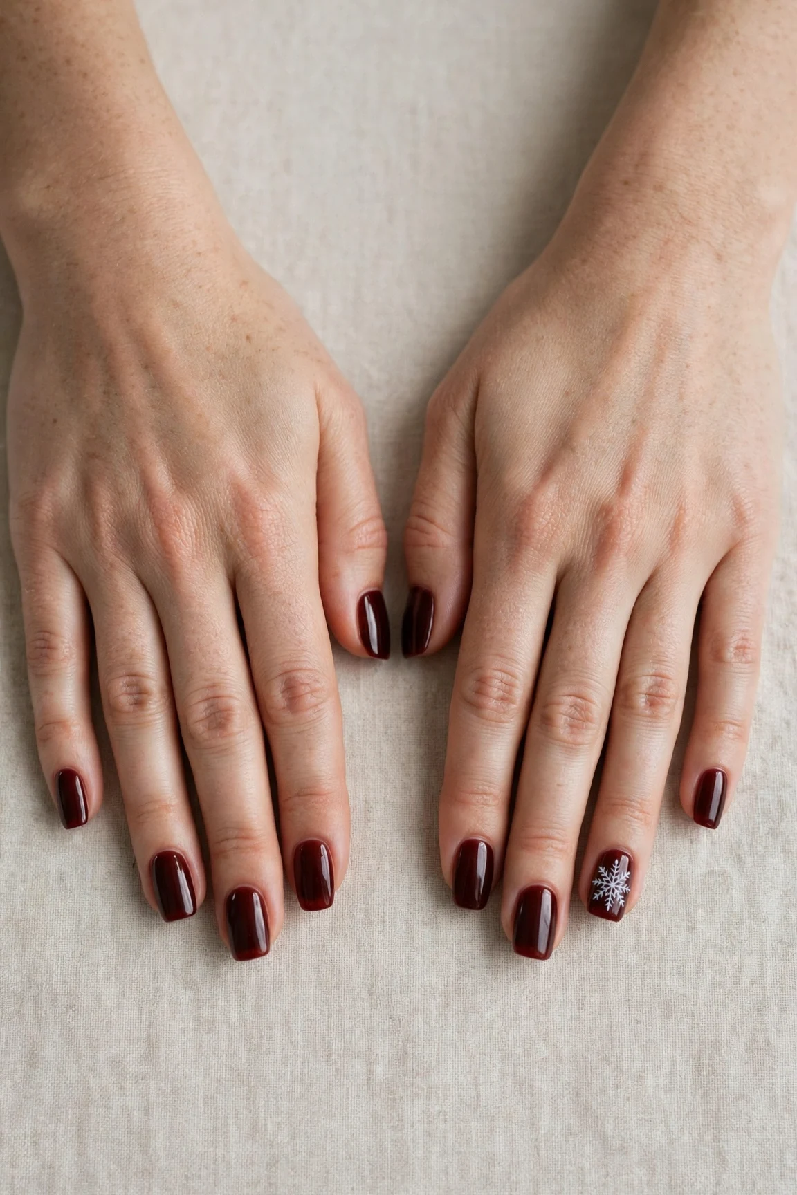 Squoval Cherry Cola Velvet Finish Nails with a sheer jelly finish and a delicate snowflake on the ring finger