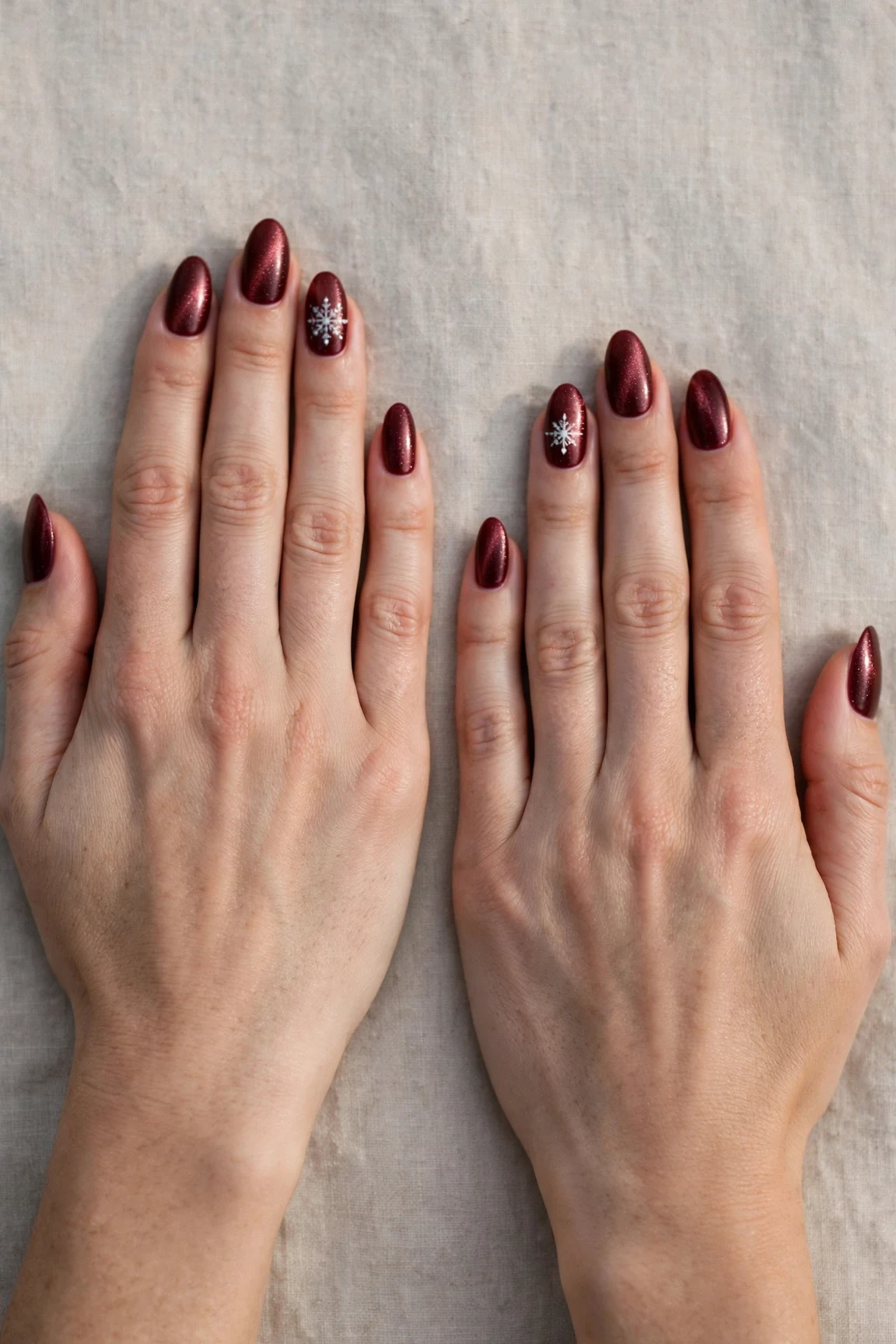 Almond Cherry Cola Velvet Finish Nails with a pearl shimmer finish and a delicate snowflake on the ring finger