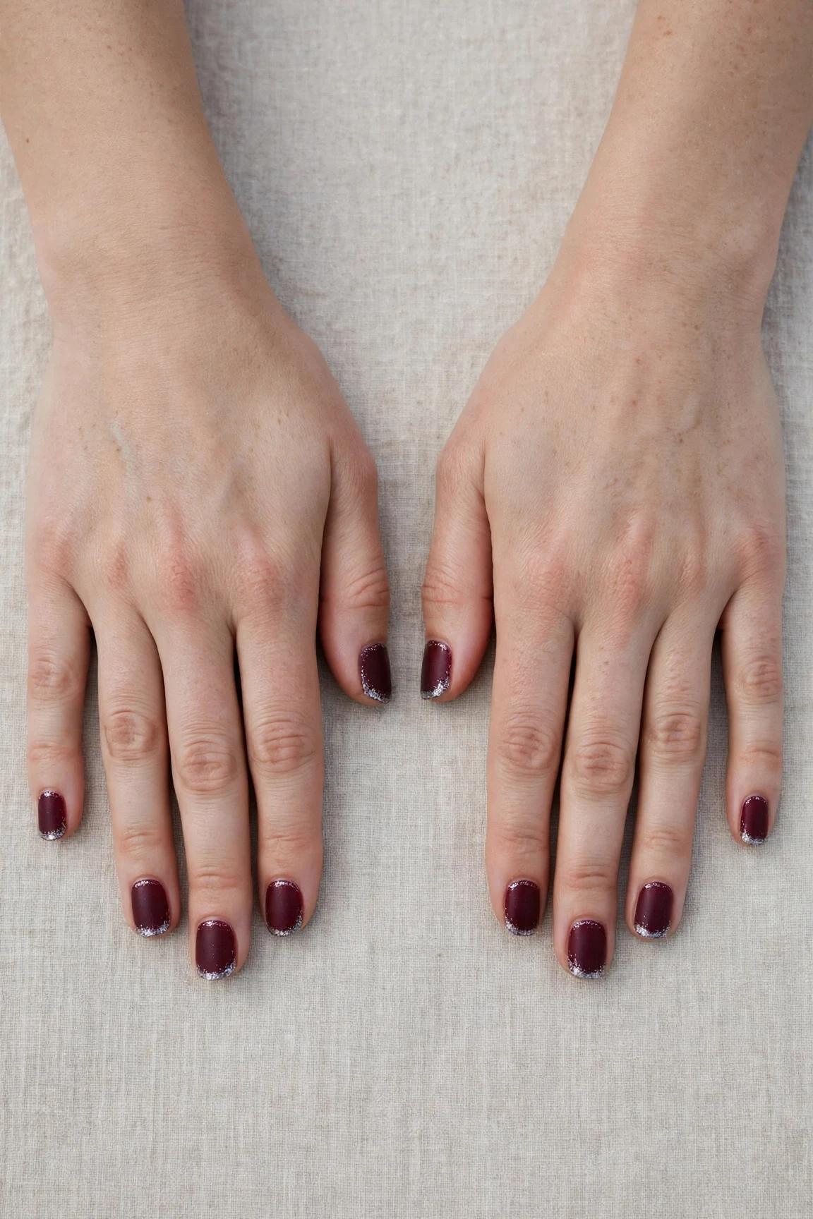 Short Round Cherry Cola Velvet Finish Nails with a frosted shimmer finish and silver shimmer tips
