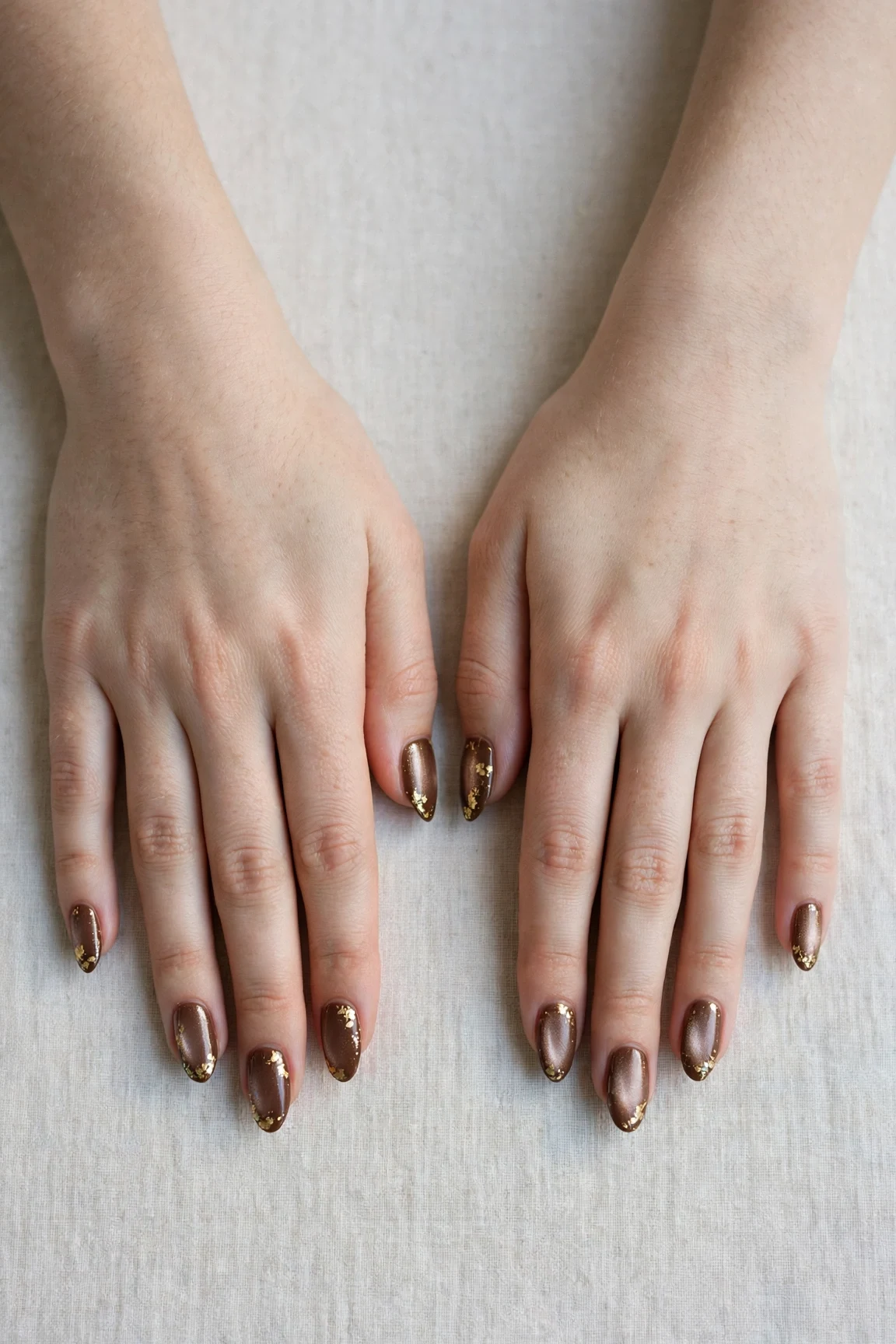 Almond Chocolate Brown Christmas Nail Art with a pearl shimmer finish and gold foil accents