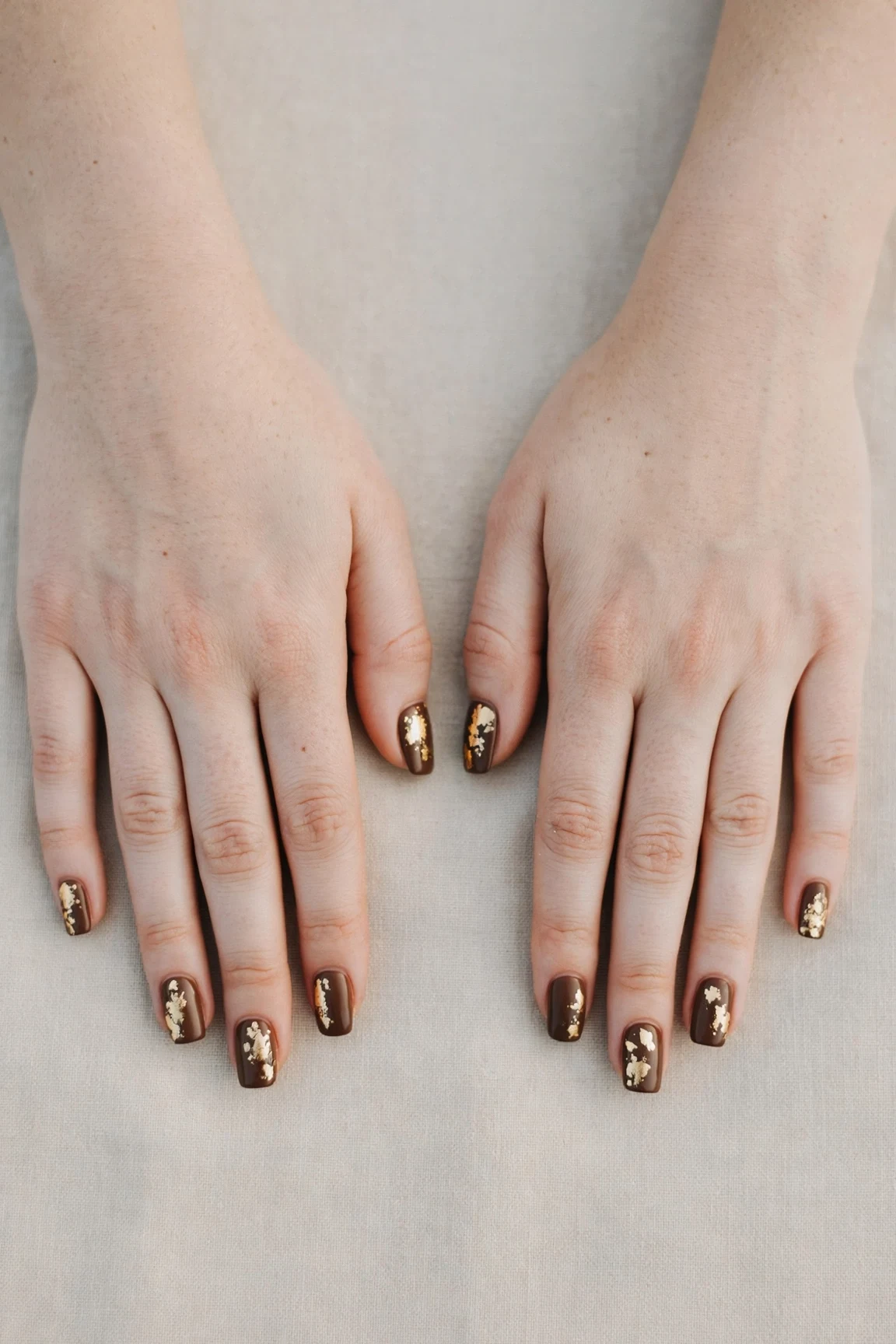 Squoval Chocolate Brown Christmas Nail Art with a creamy opaque finish and gold foil accents