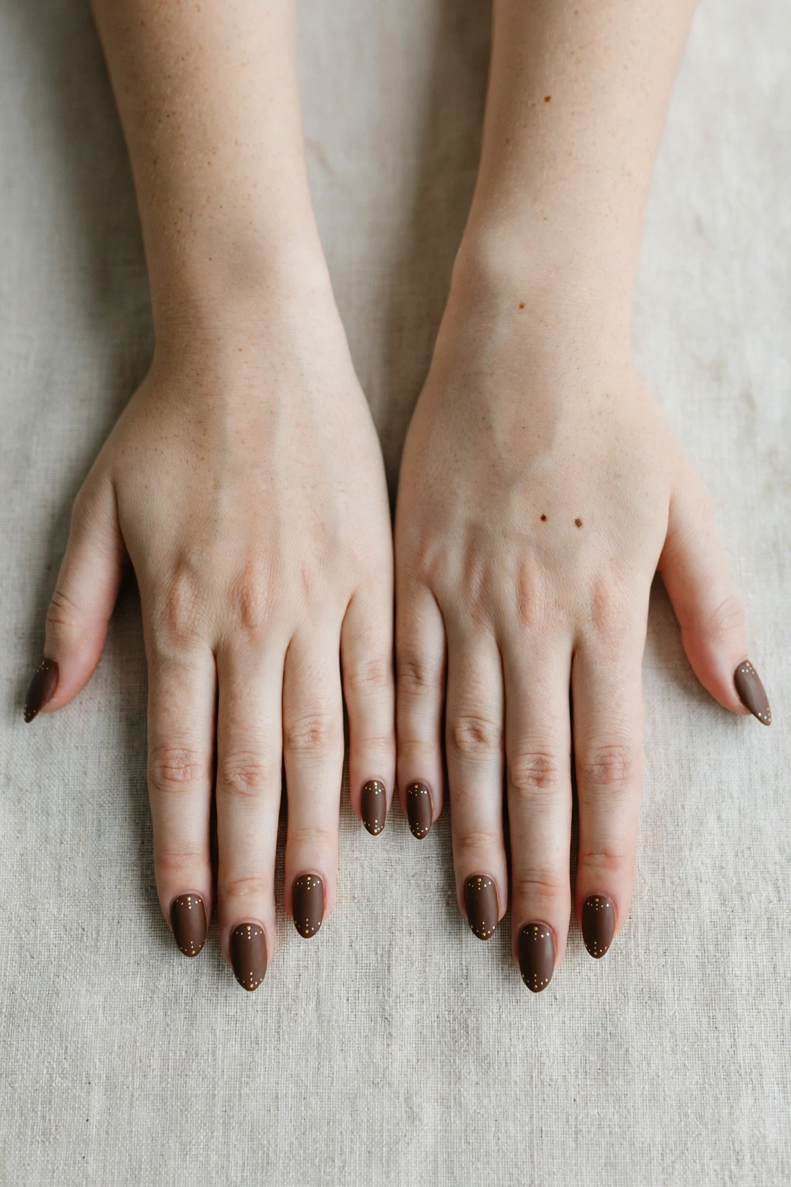 Almond Chocolate Brown Christmas Nail Art with a soft matte finish and tiny gold dots