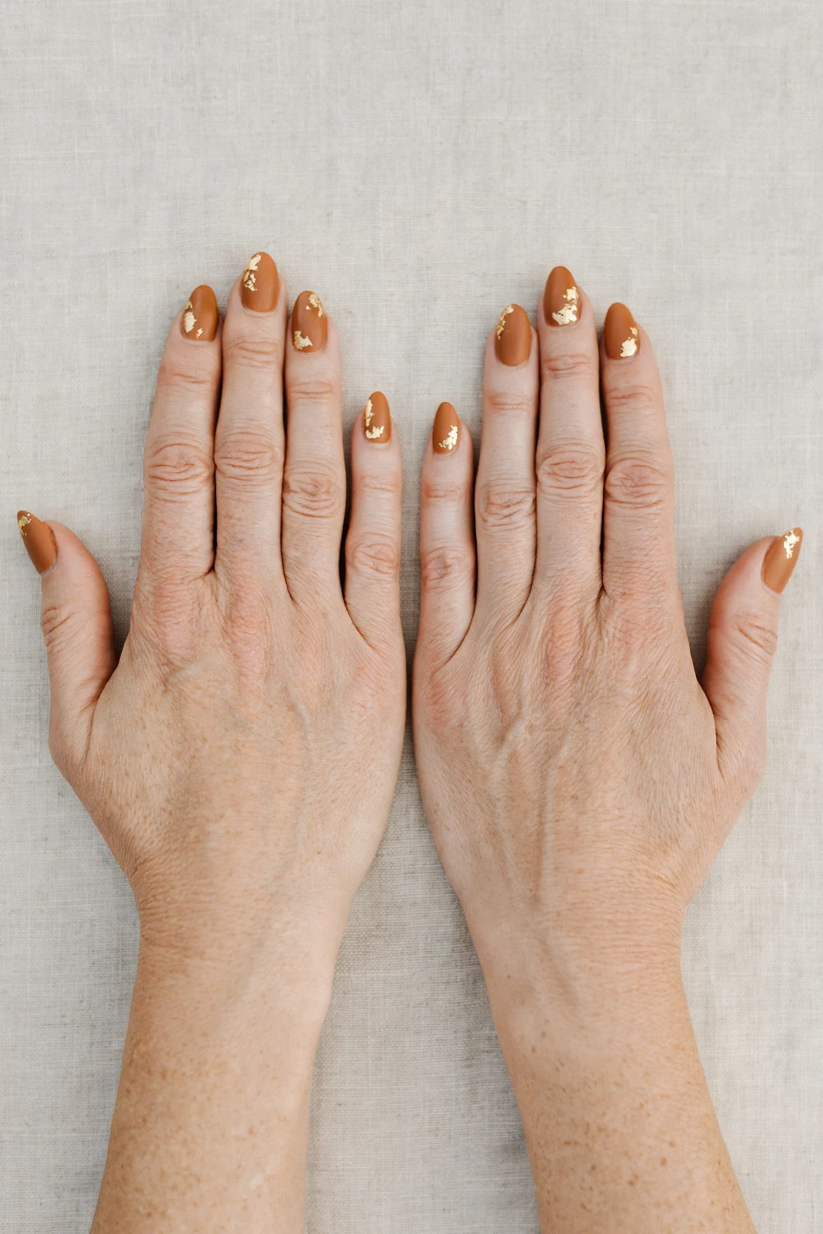 Almond Cinnamon Caramel Nail Art with a soft matte finish and gold foil accents