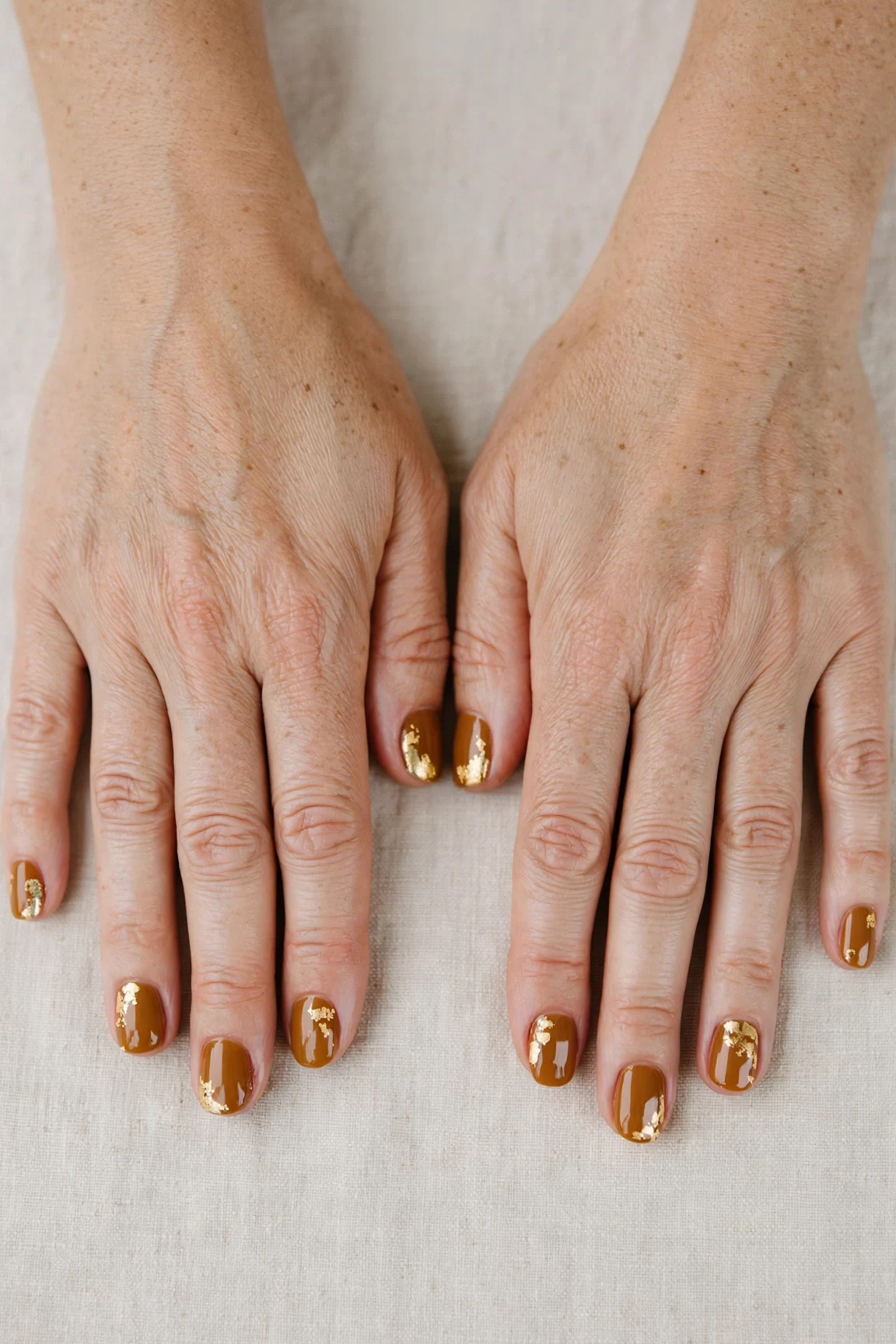 Short Round Cinnamon Caramel Nail Art with a deep glossy shine and gold foil accents