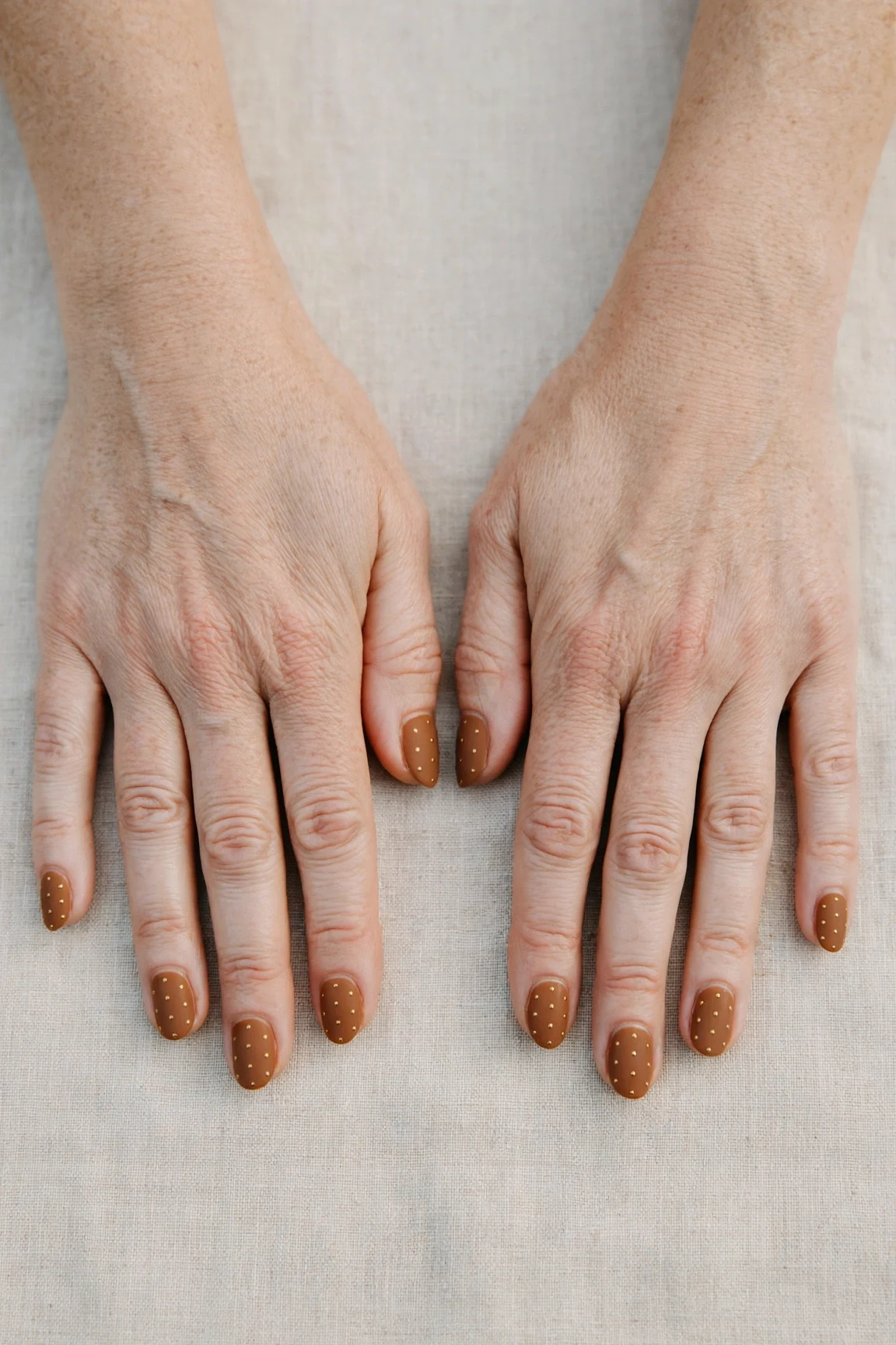 Oval Cinnamon Caramel Nail Art with a velvet matte finish and tiny gold dots