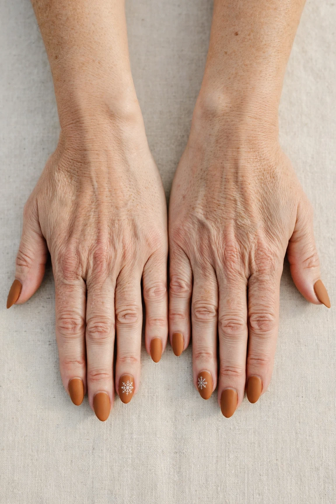 Almond Cinnamon Caramel Nail Art with a soft matte finish and a delicate snowflake on the ring finger