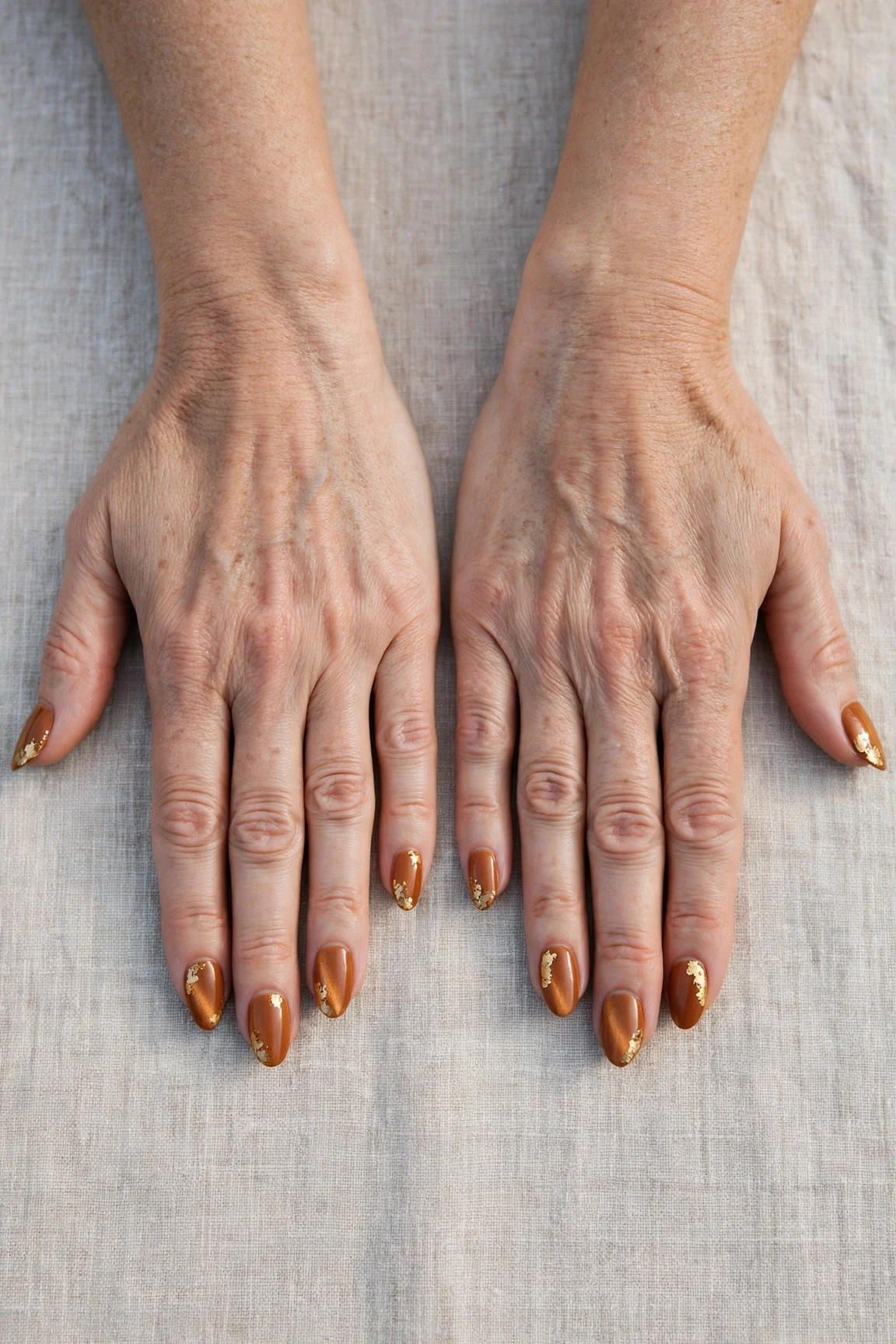 Cinnamon Spice Almond Nails with a satin finish and gold foil accents