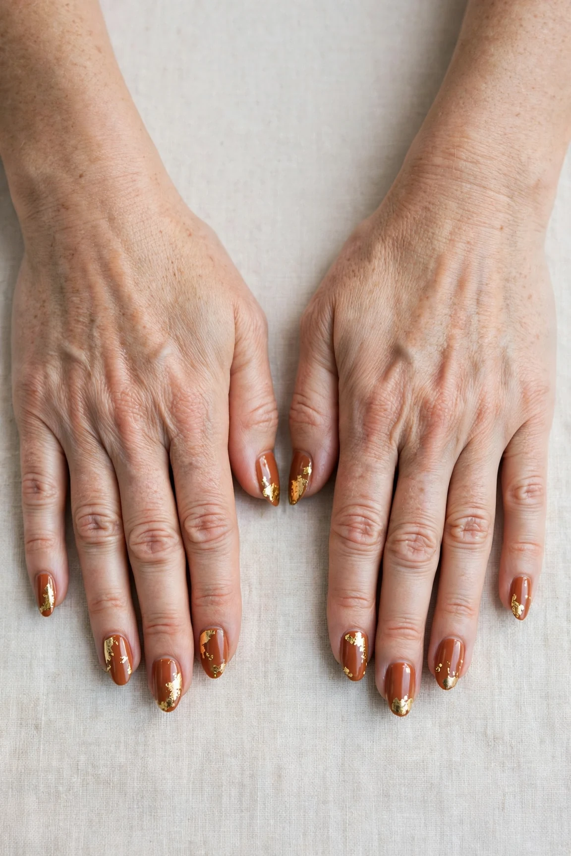 Cinnamon Spice Almond Nails with a glassy gel finish and gold foil accents