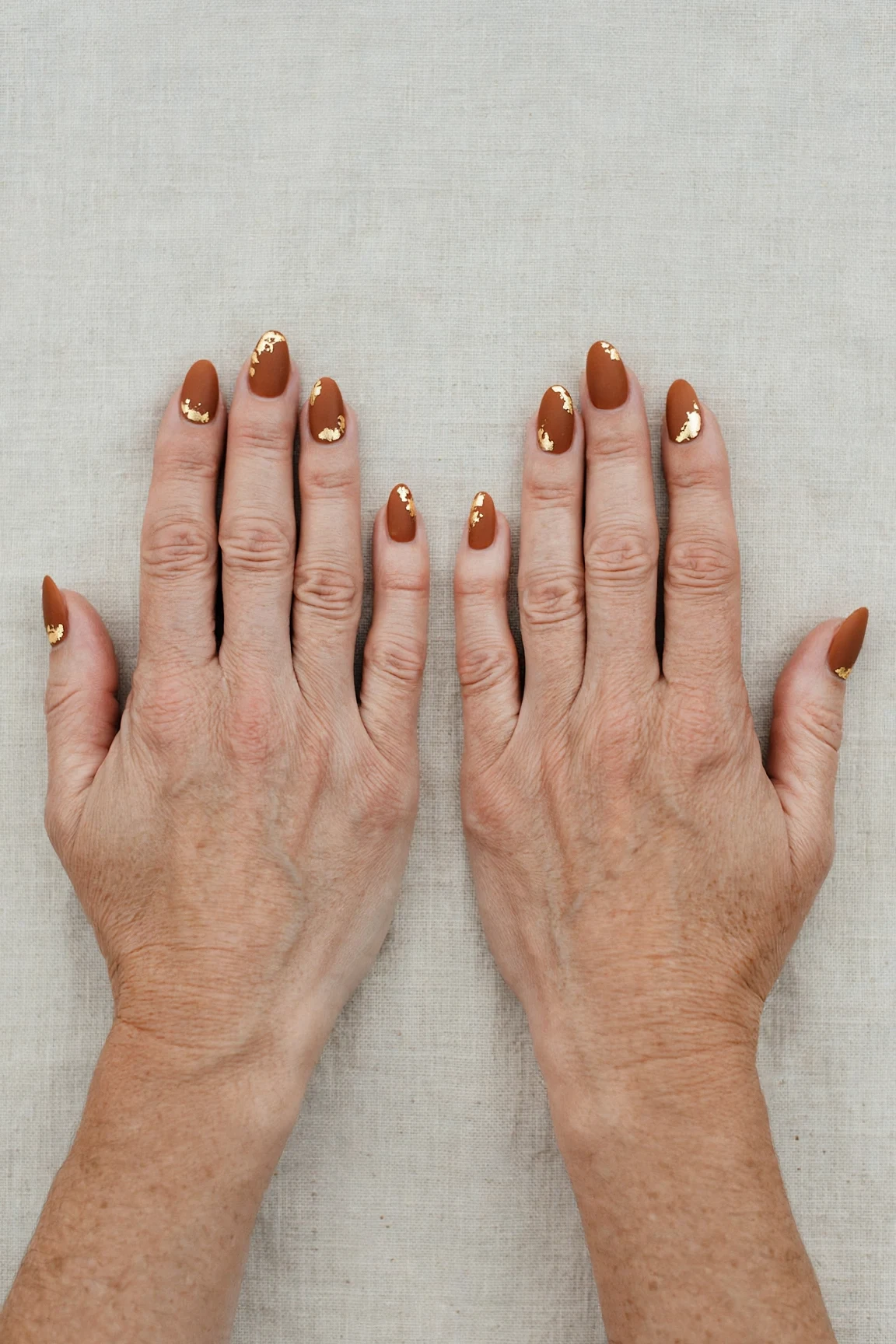 22 Cinnamon Spice Matte Nails For Women Over 40 For January Parties That Are Chic, Warm and Elegant 3 Almond Cinnamon Spice Matte Nails with a soft matte finish and gold foil accents