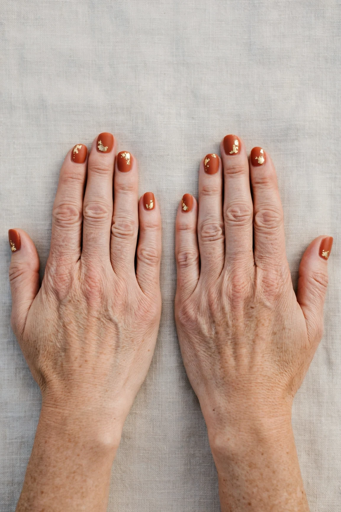 Cinnamon Terracotta Short Nails with a velvet matte finish and gold foil accents