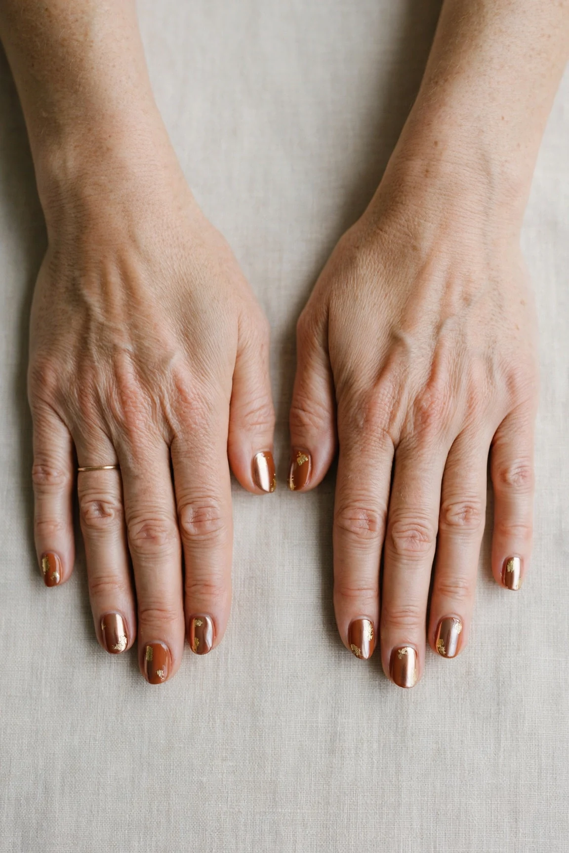 Cinnamon Terracotta Short Nails with a chrome shine and gold foil accents