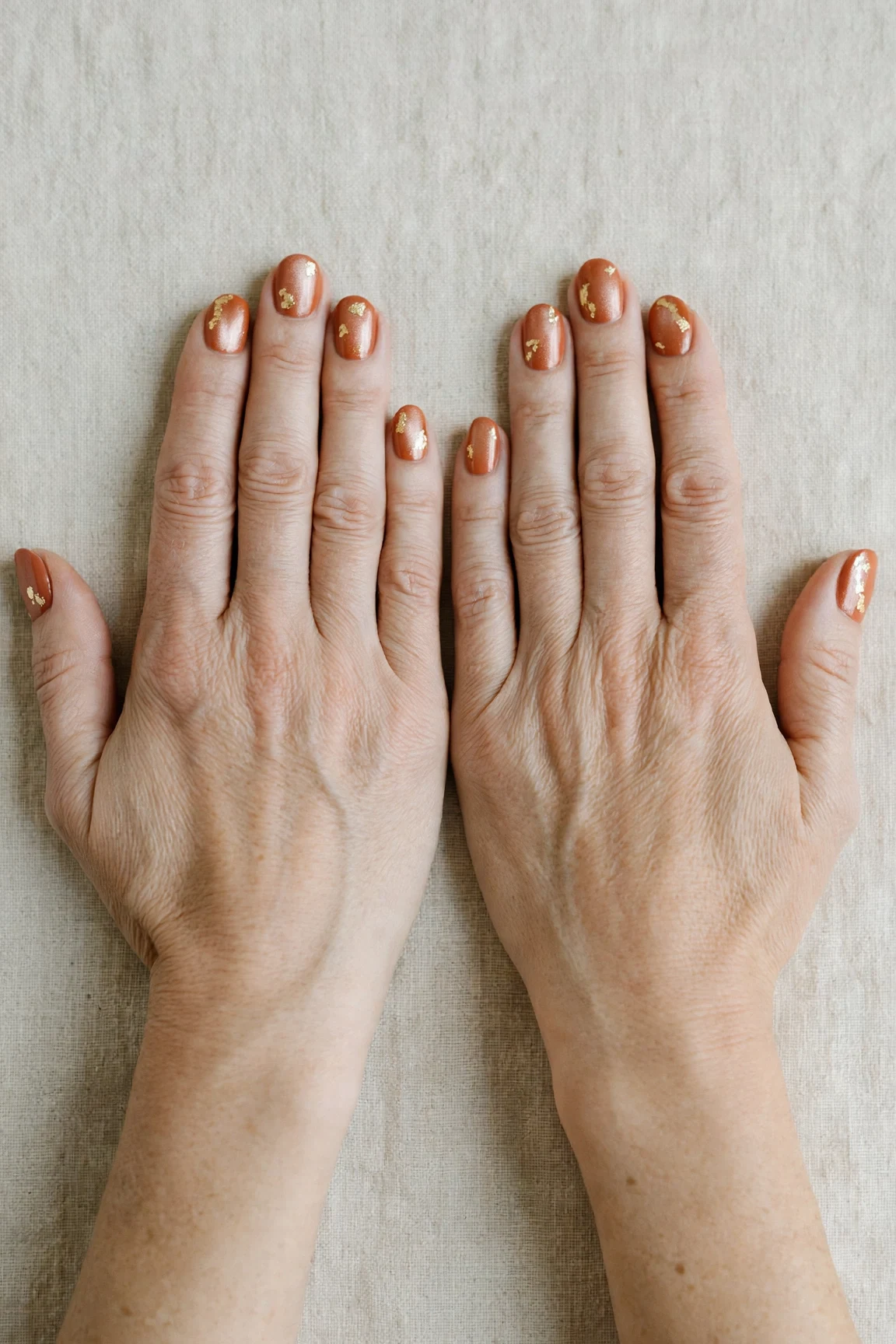 Cinnamon Terracotta Short Nails with a pearl shimmer finish and gold foil accents