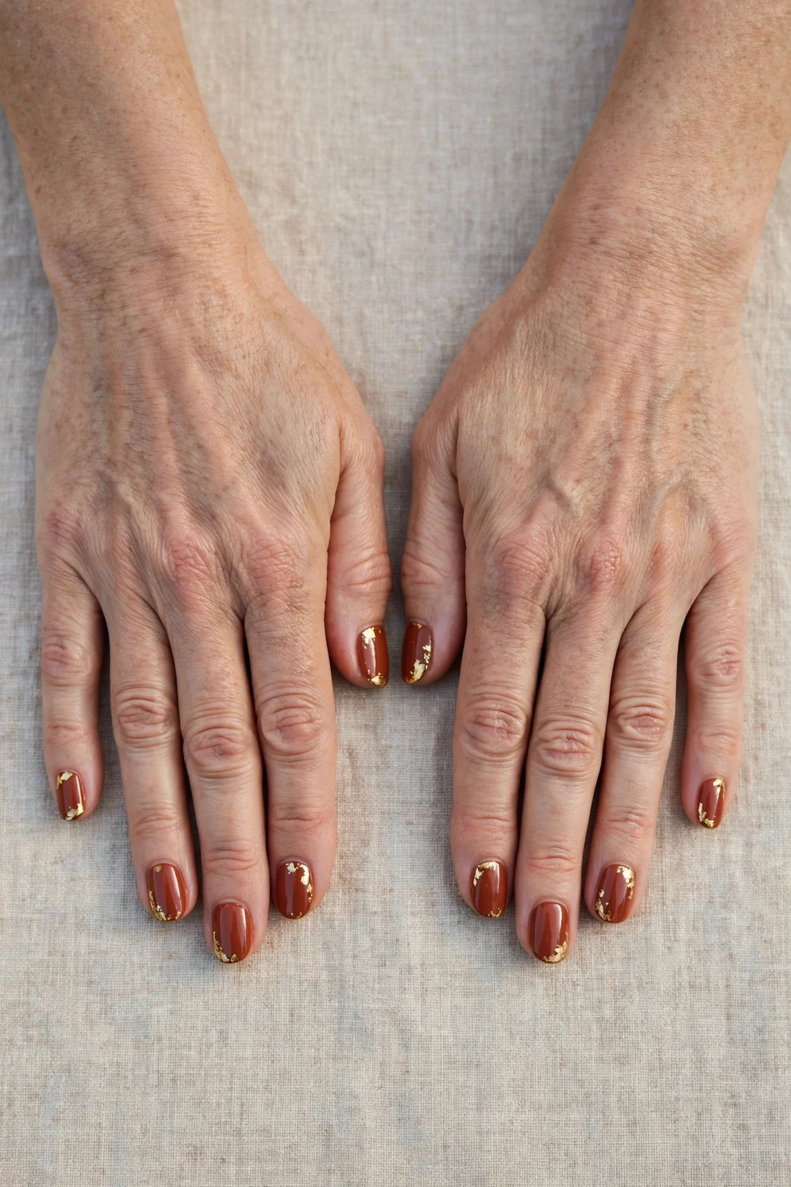 Cinnamon Terracotta Short Nails with a deep glossy shine and gold foil accents