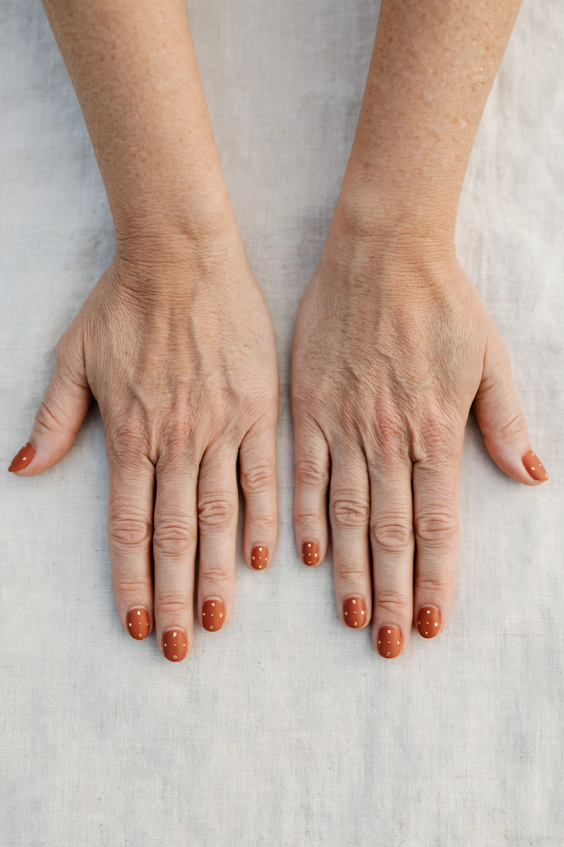 Cinnamon Terracotta Short Nails with a soft matte finish and tiny gold dots
