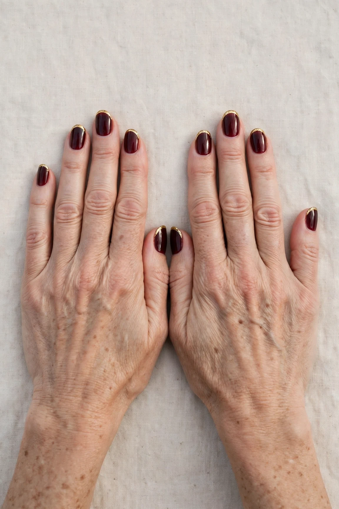 Dark Cherry Velvet French Tip Nails with a sheer jelly finish and gold French tips
