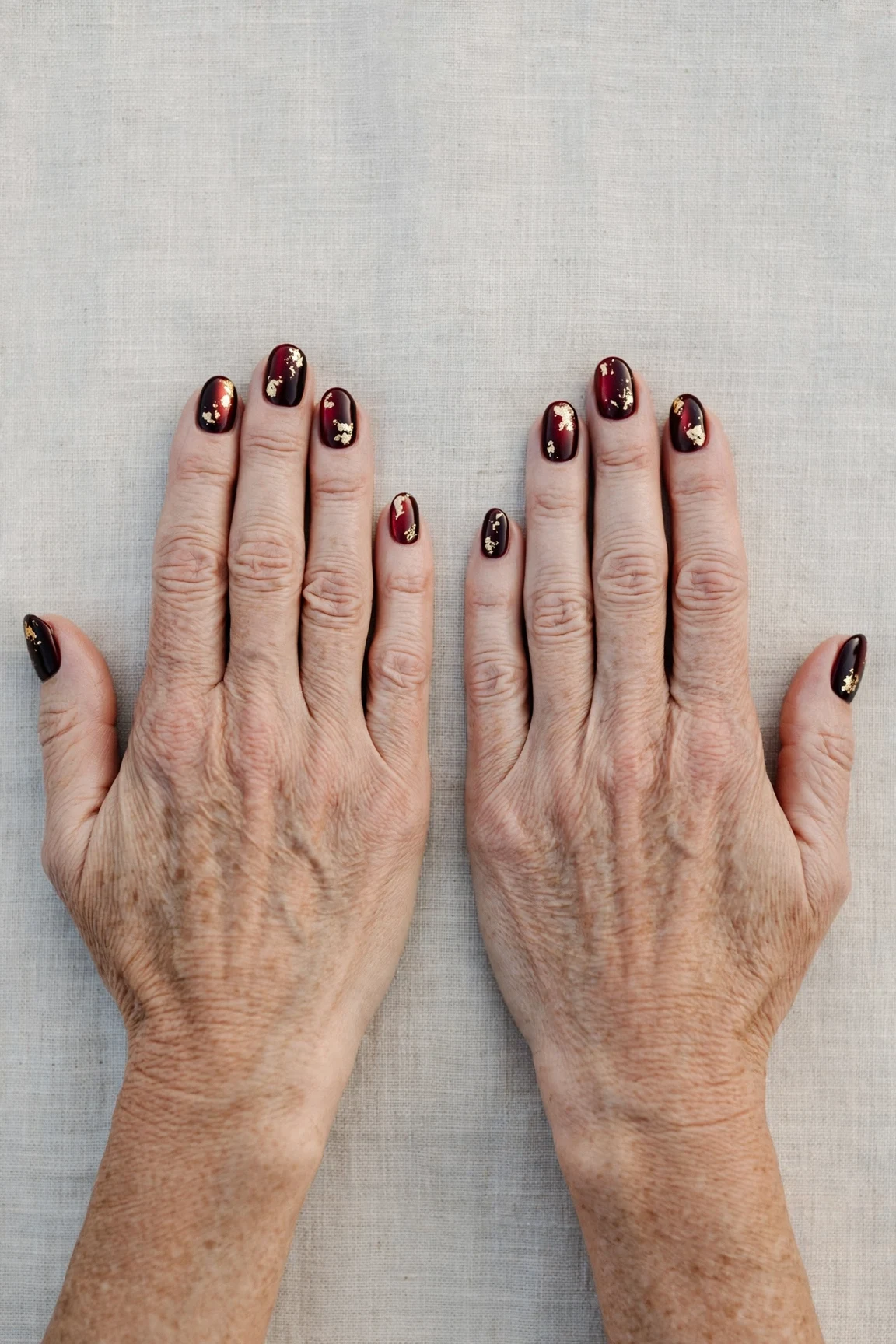 Oval Dark Cherry Velvet Manicure Ideas with a satin finish and gold foil accents