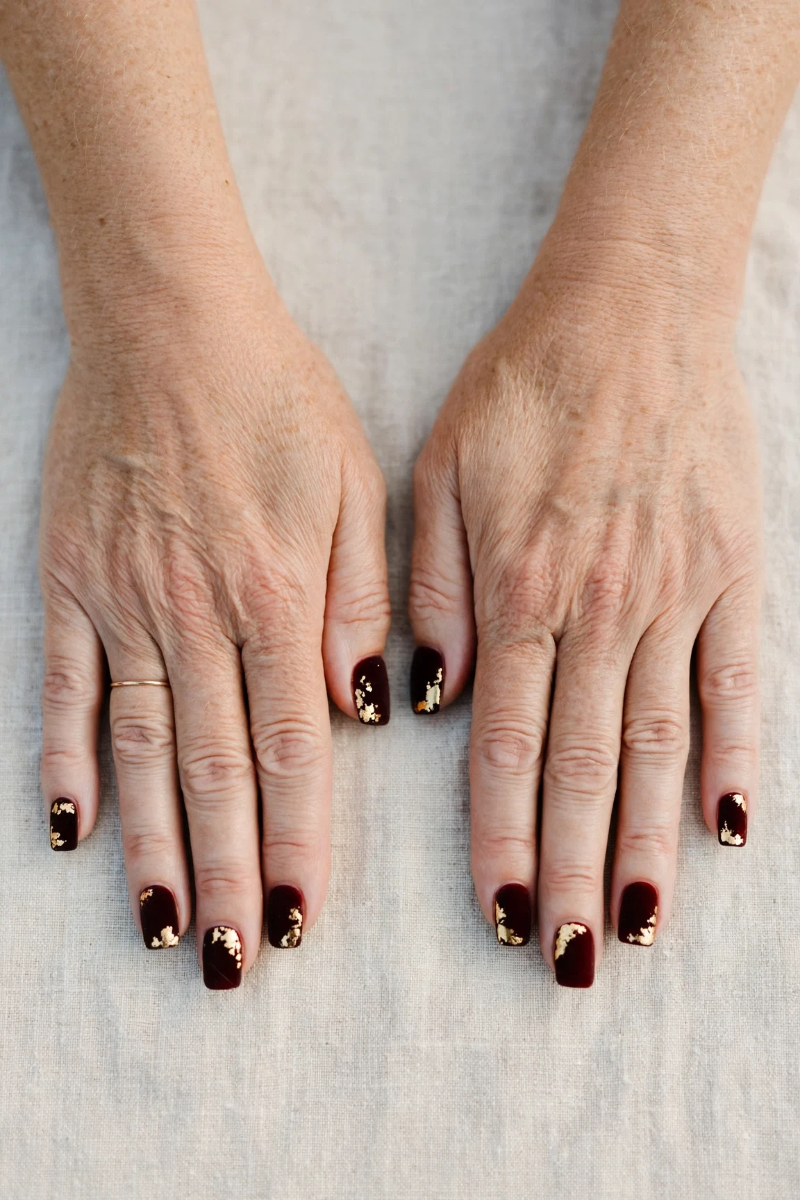 Squoval Dark Cherry Velvet Manicure Ideas with a creamy opaque finish and gold foil accents