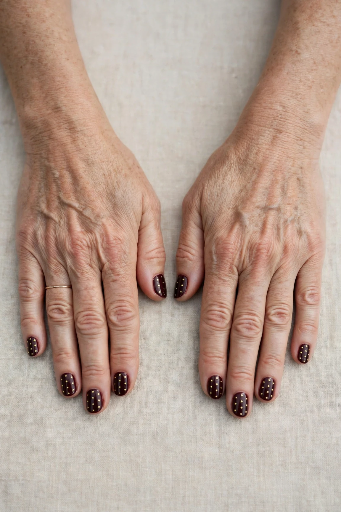 Short Oval Dark Cherry Velvet Manicure Ideas with a high-gloss finish and tiny gold dots