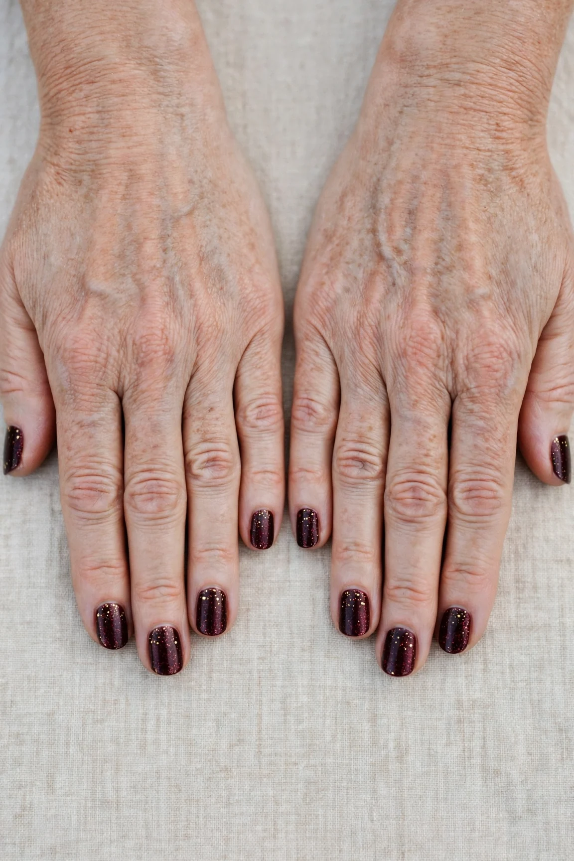 Short Oval Dark Cherry Velvet Manicure Ideas with a glitter gradient finish and tiny gold dots