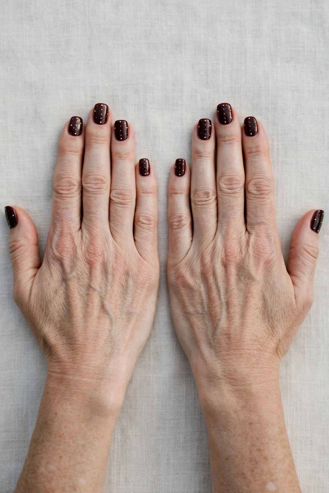 Squoval Dark Cherry Velvet Manicure Ideas with a creamy opaque finish and tiny gold dots