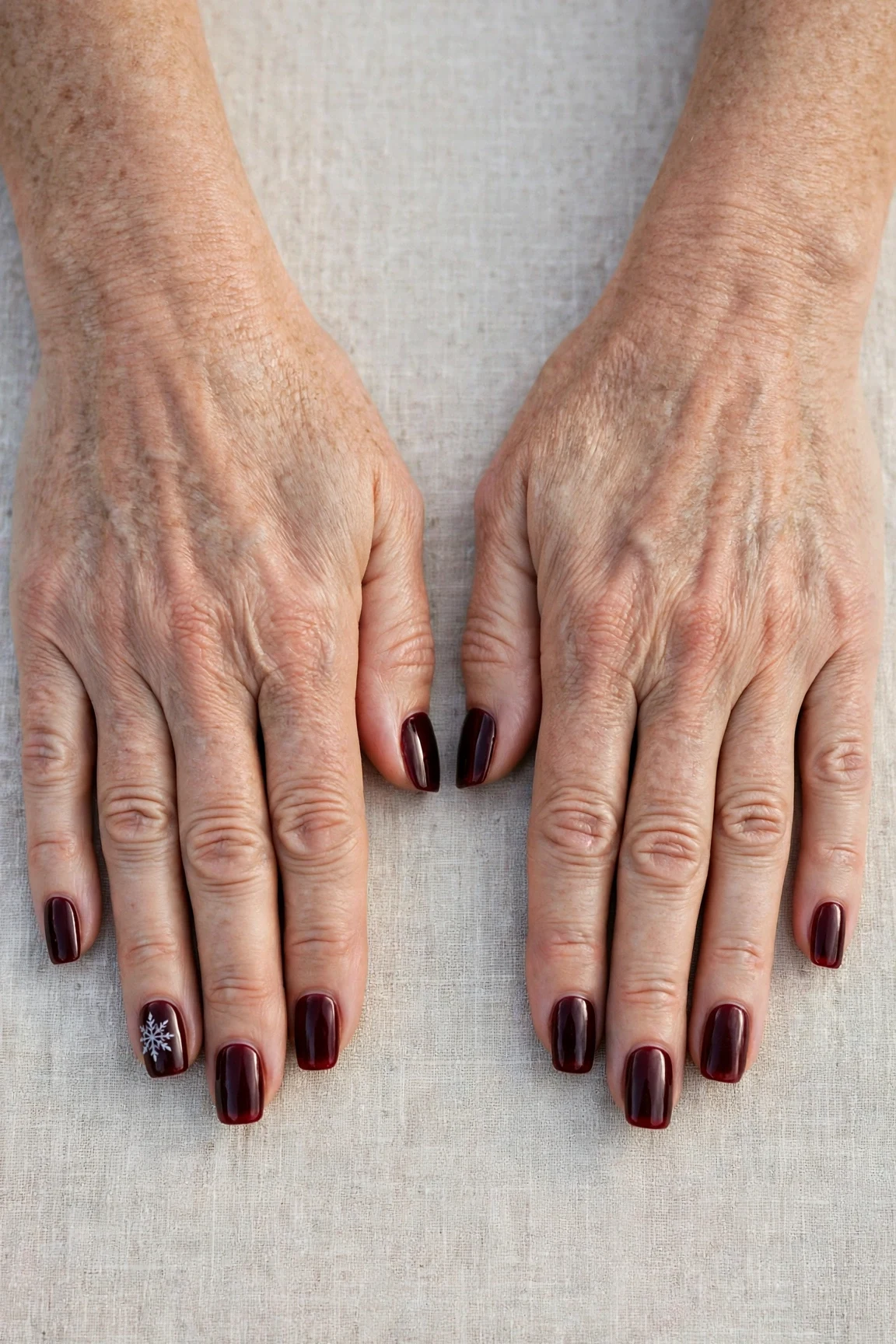 Squoval Dark Cherry Velvet Manicure Ideas with a sheer jelly finish and a delicate snowflake on the ring finger