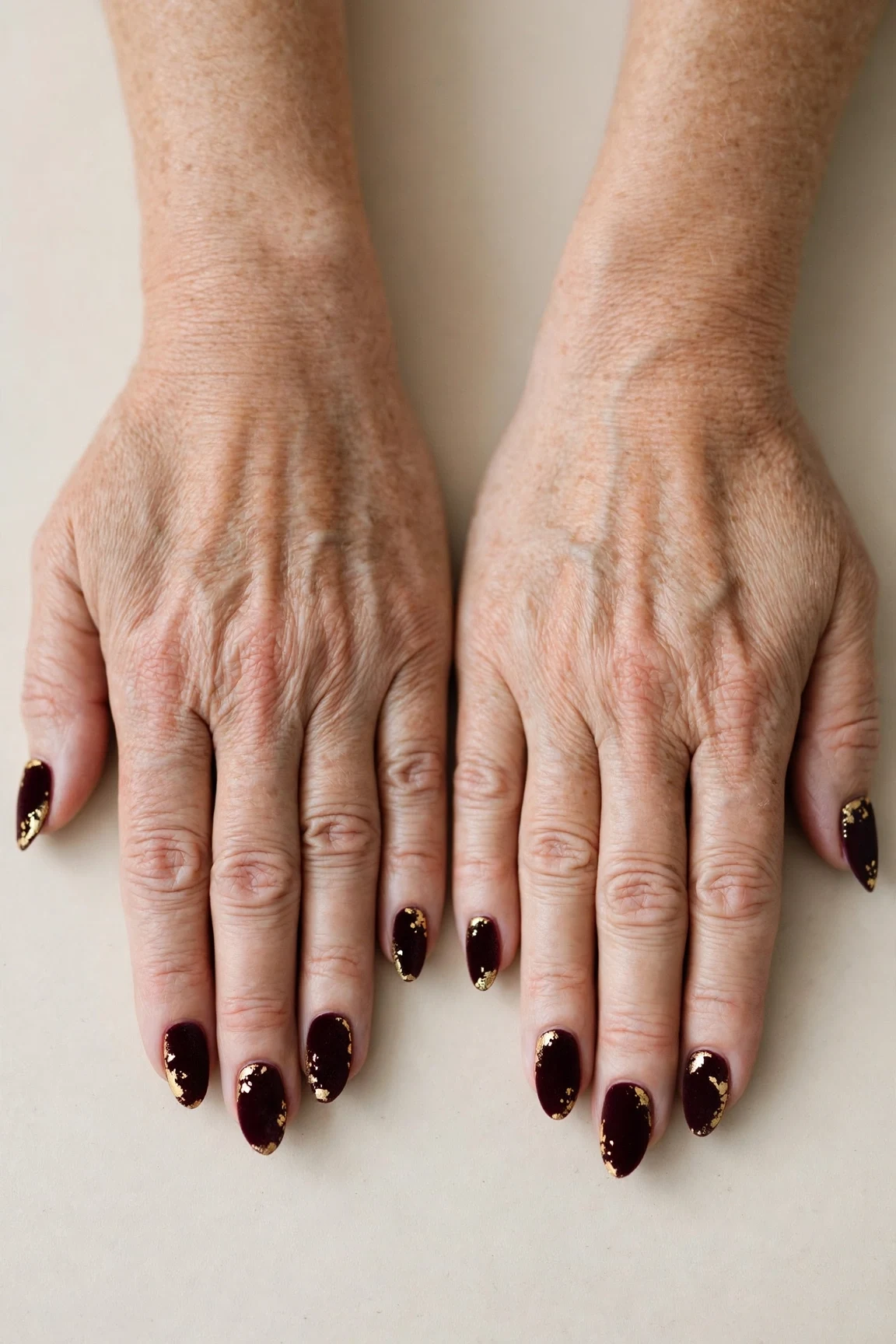 Almond Dark Cherry Velvet Nails with a soft matte finish and gold foil accents