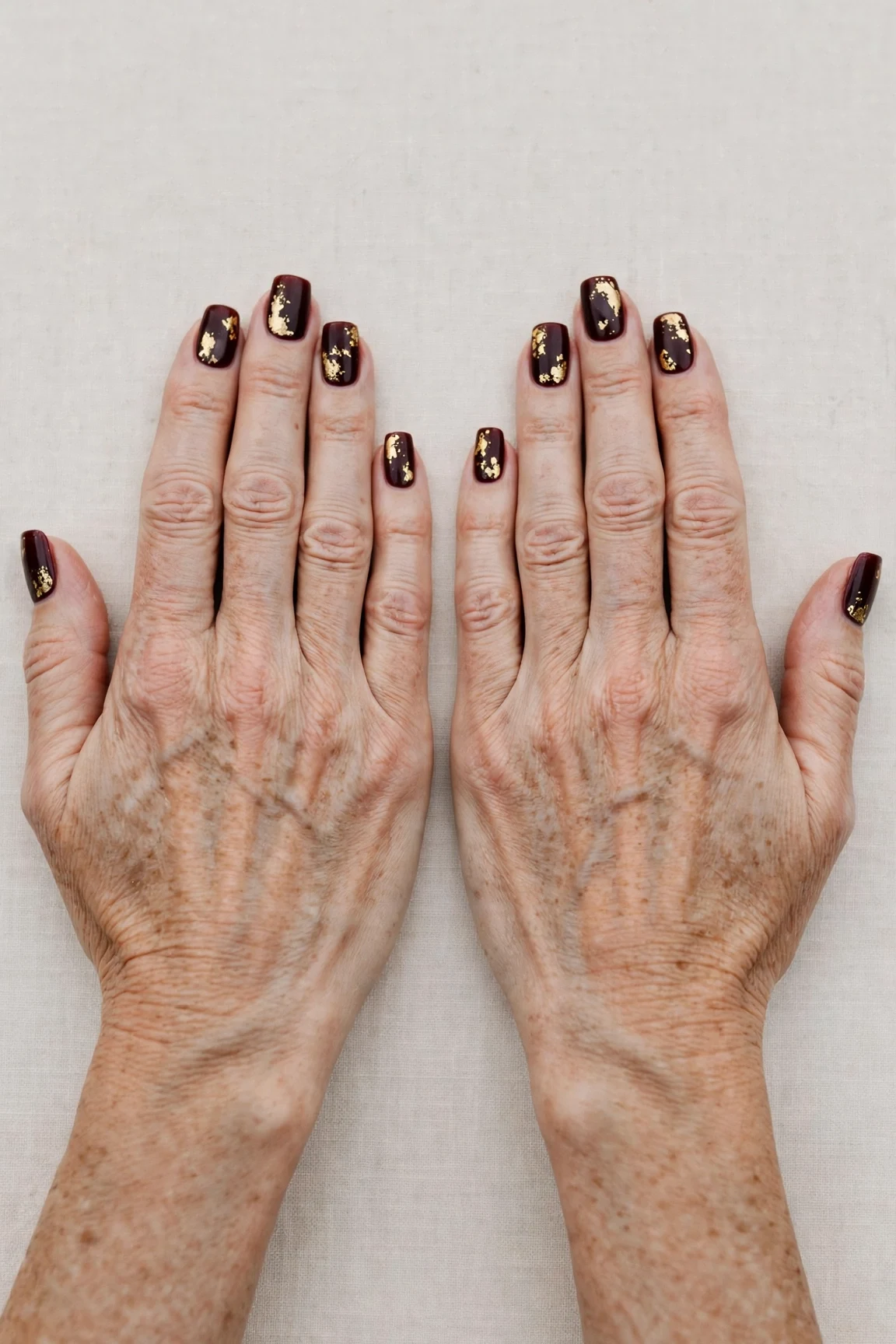 Squoval Dark Cherry Velvet Nails with a creamy opaque finish and gold foil accents