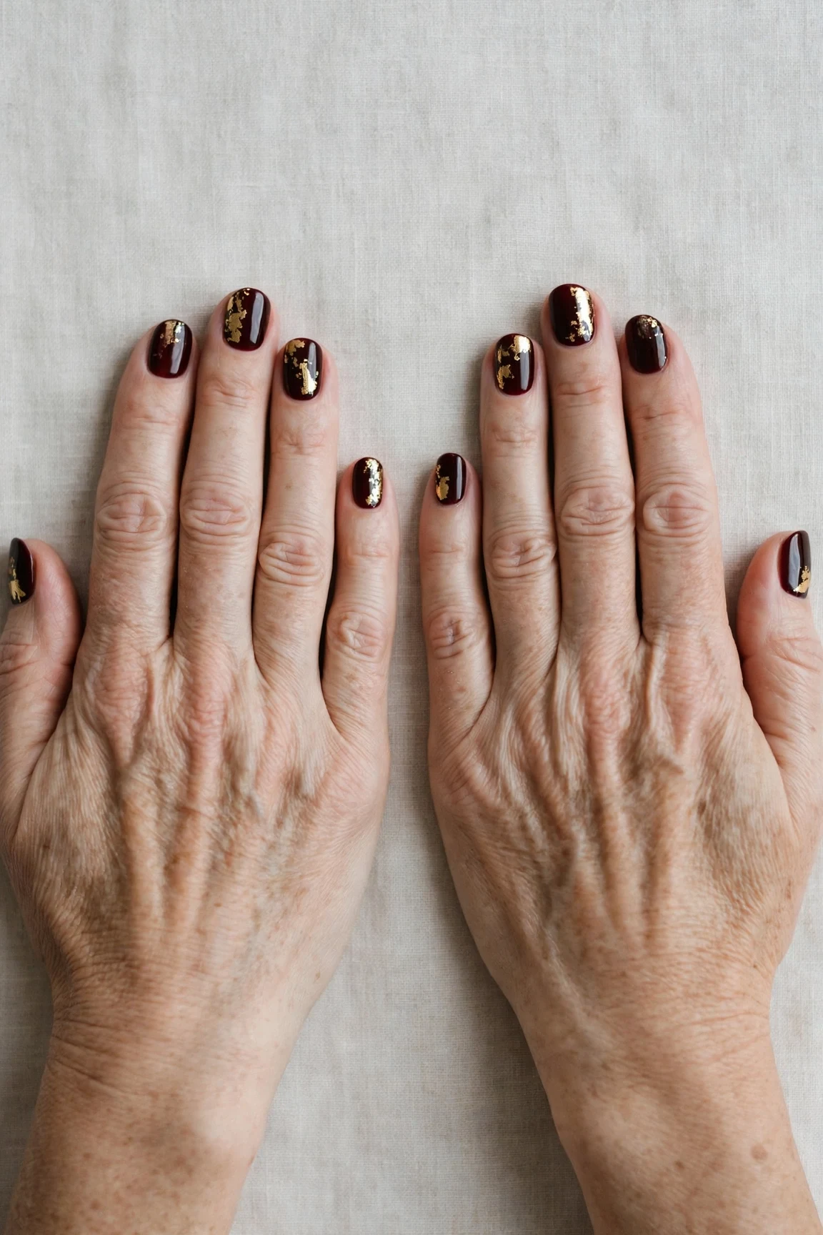 Dark Cherry Velvet Short Nails with a chrome shine and gold foil accents