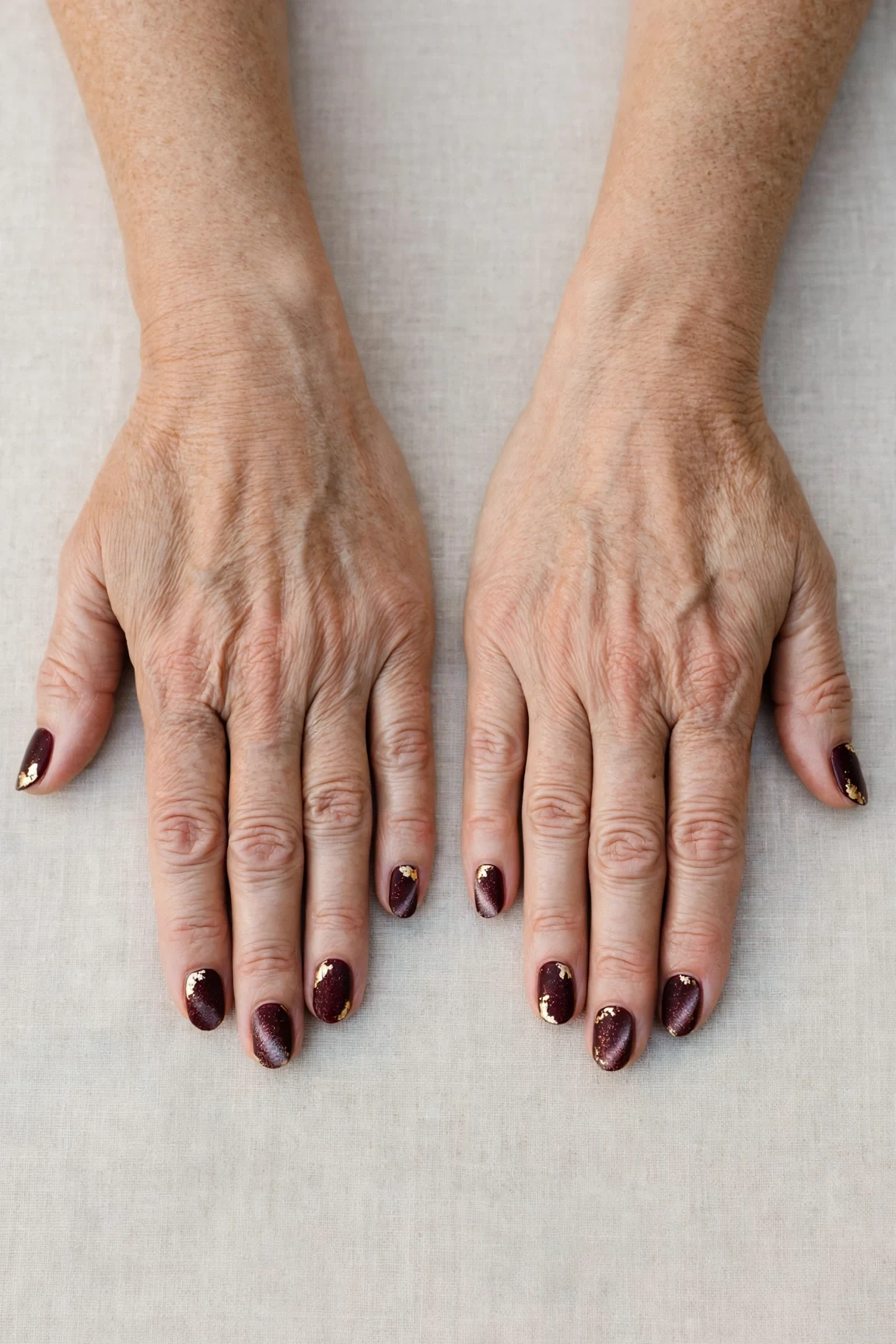 Dark Cherry Velvet Short Nails with a frosted shimmer finish and gold foil accents